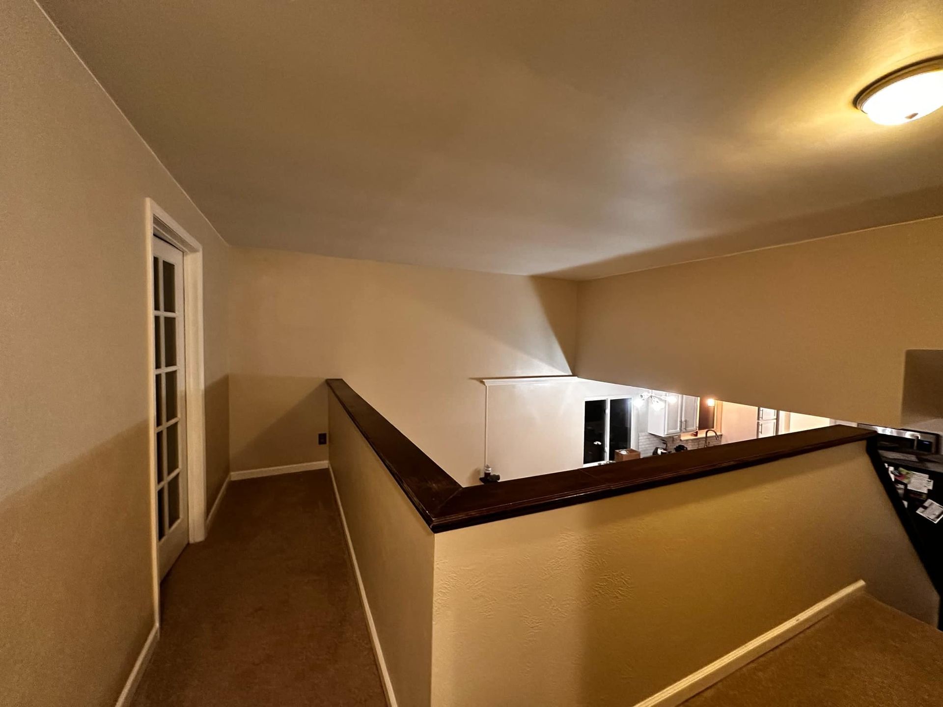 A hallway in a house with a staircase leading up to the second floor