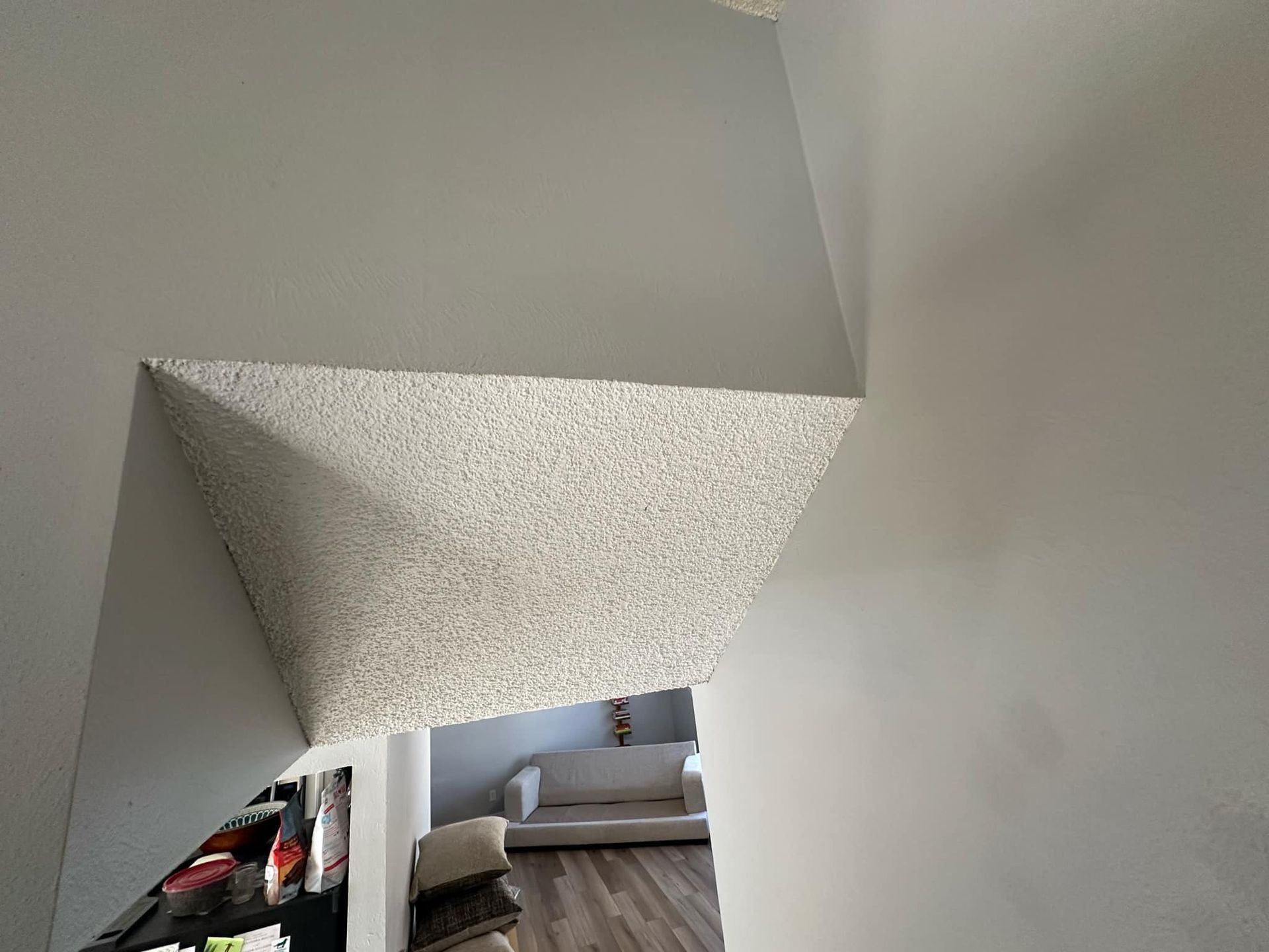 A view of a living room from the bottom of a staircase.