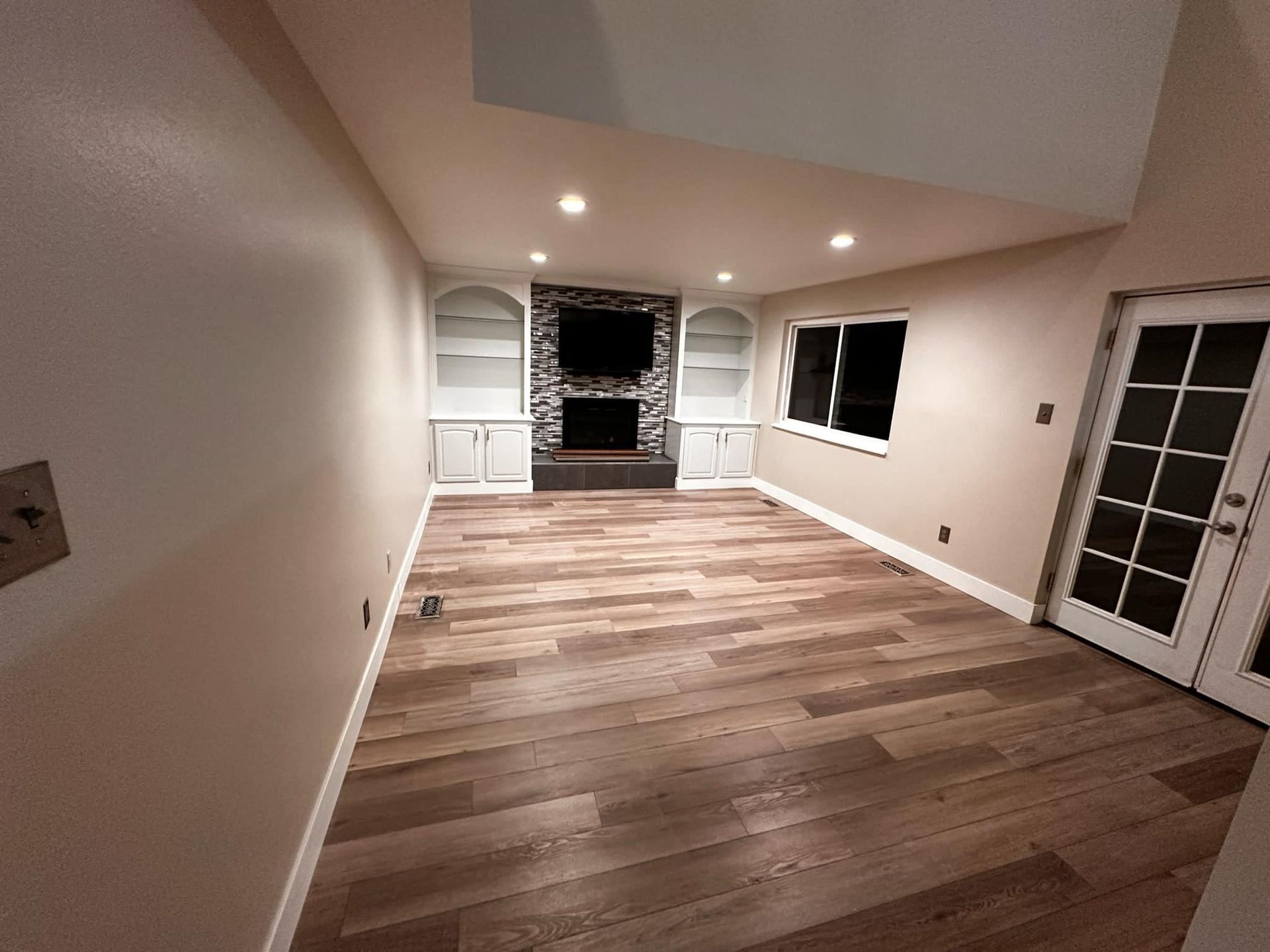 A living room with hardwood floors and a fireplace.