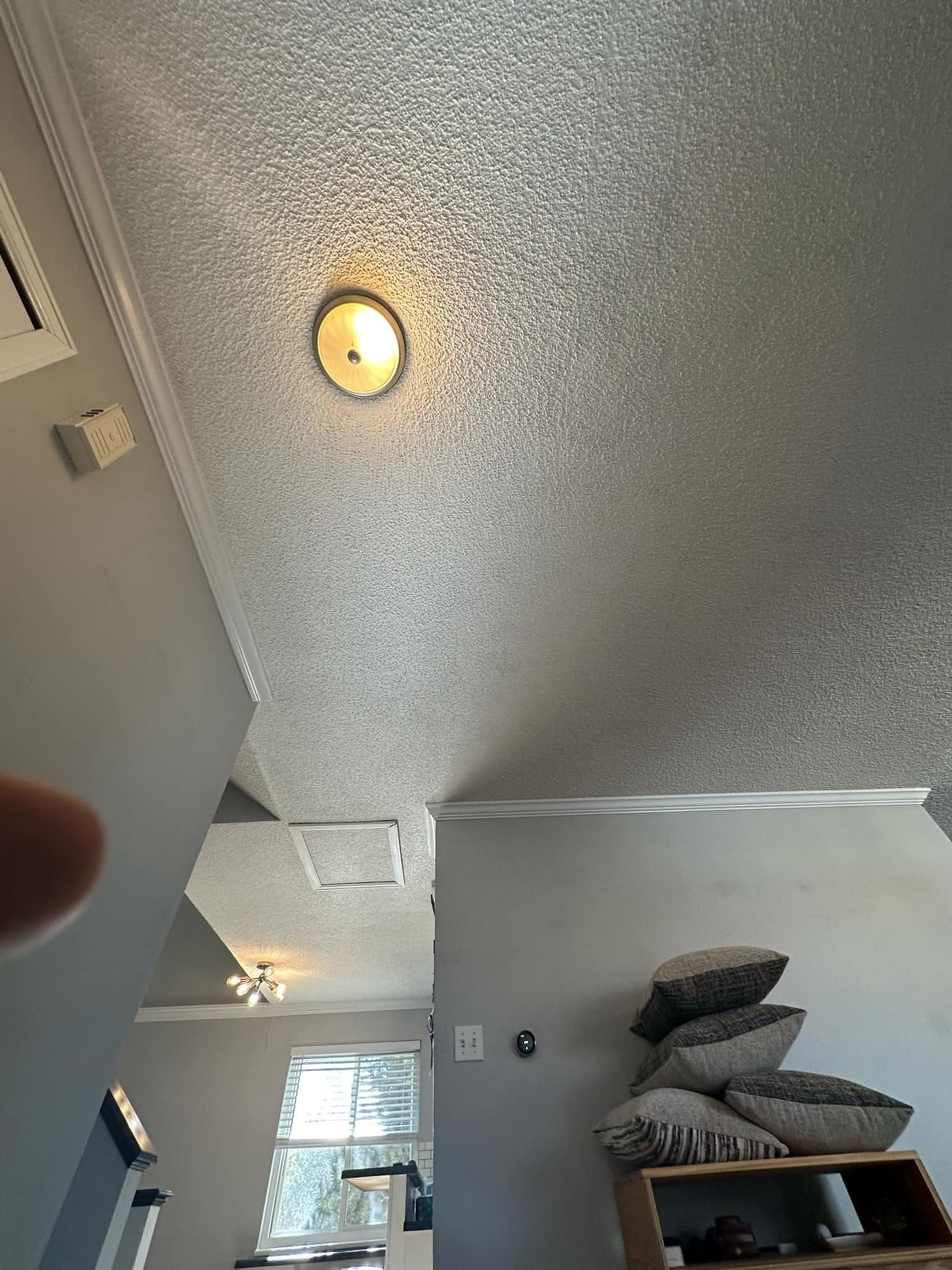 A person is looking up at the ceiling of a living room.