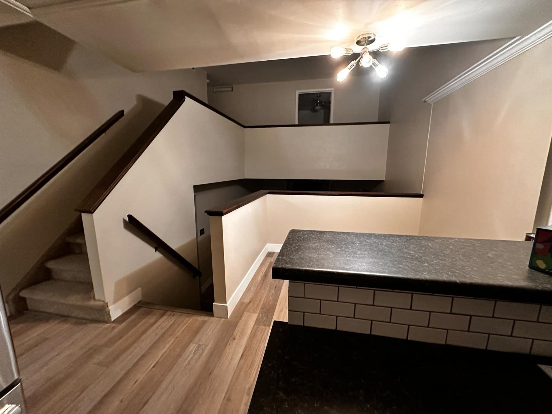 An empty room with stairs and a counter top