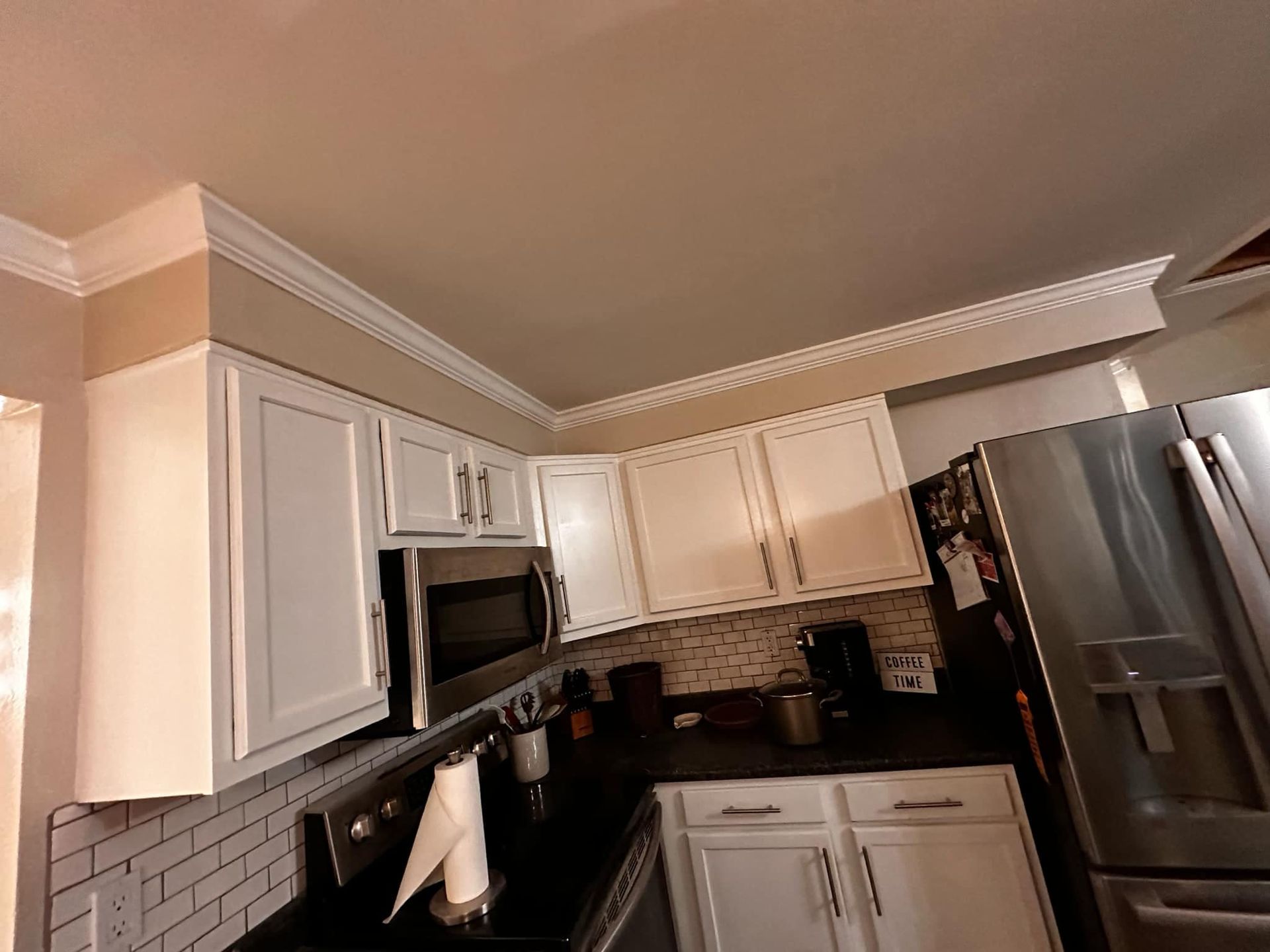 A kitchen with white cabinets and stainless steel appliances.