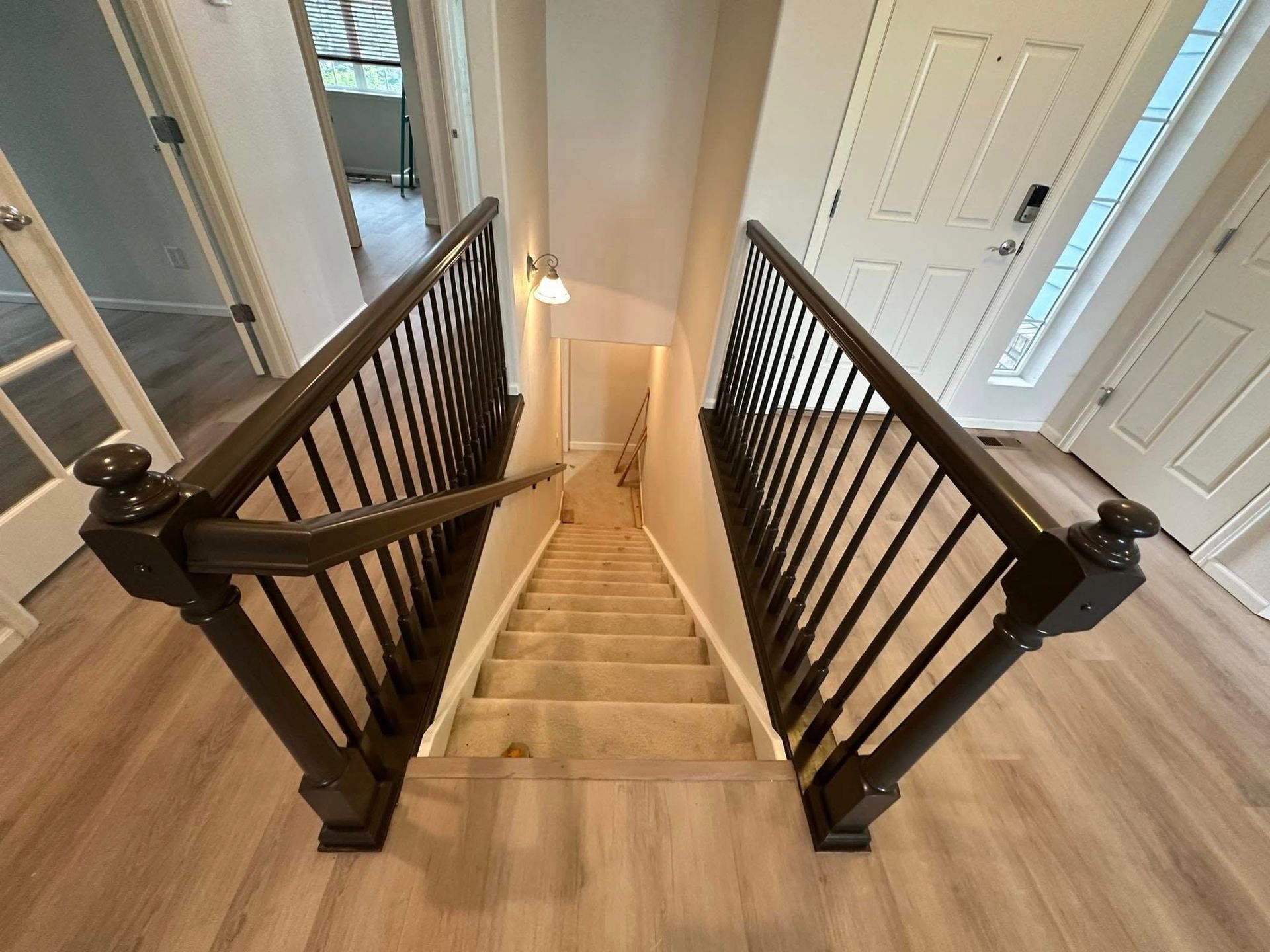 A staircase with a black railing leading up to the second floor of a house.