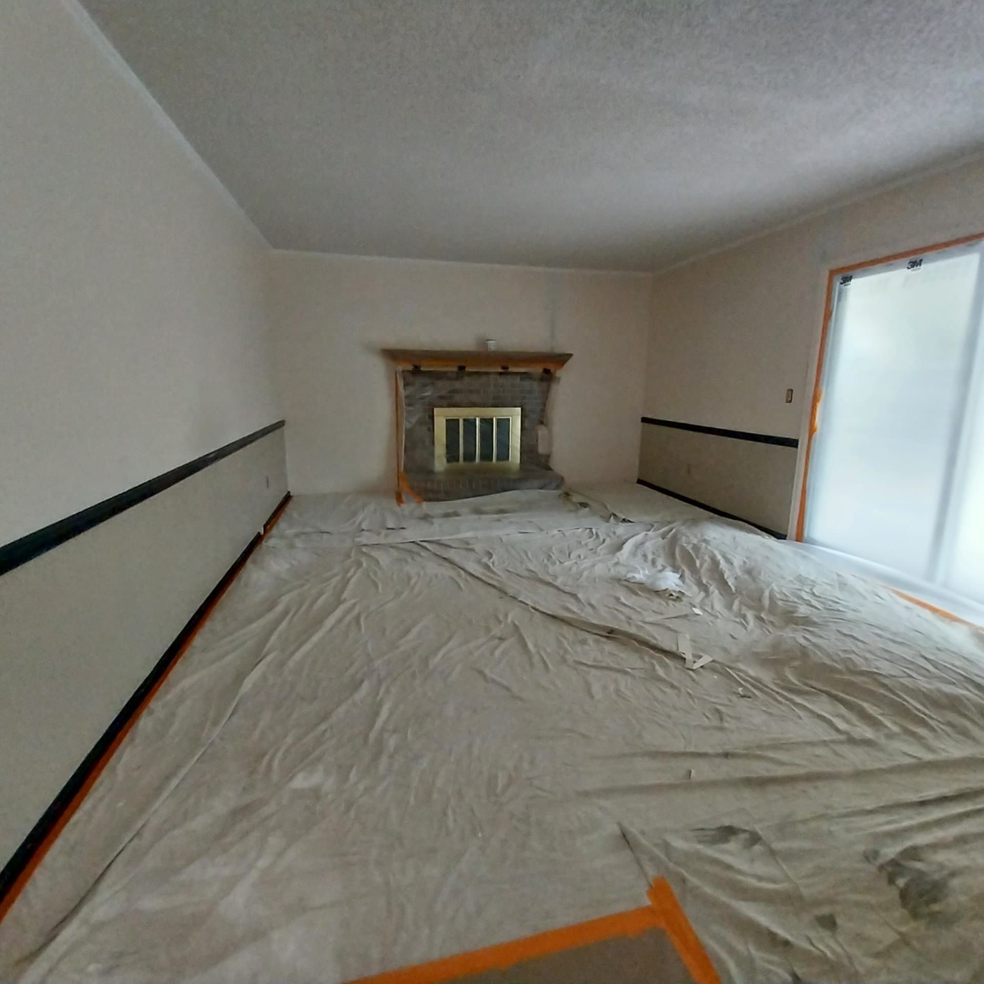 A living room with a fireplace and a blanket on the floor