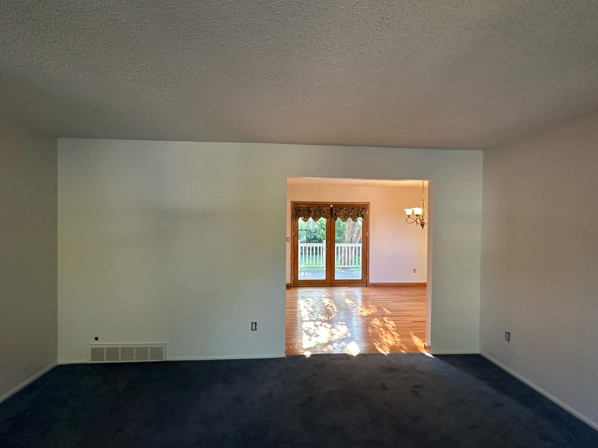 An empty living room with a sliding glass door