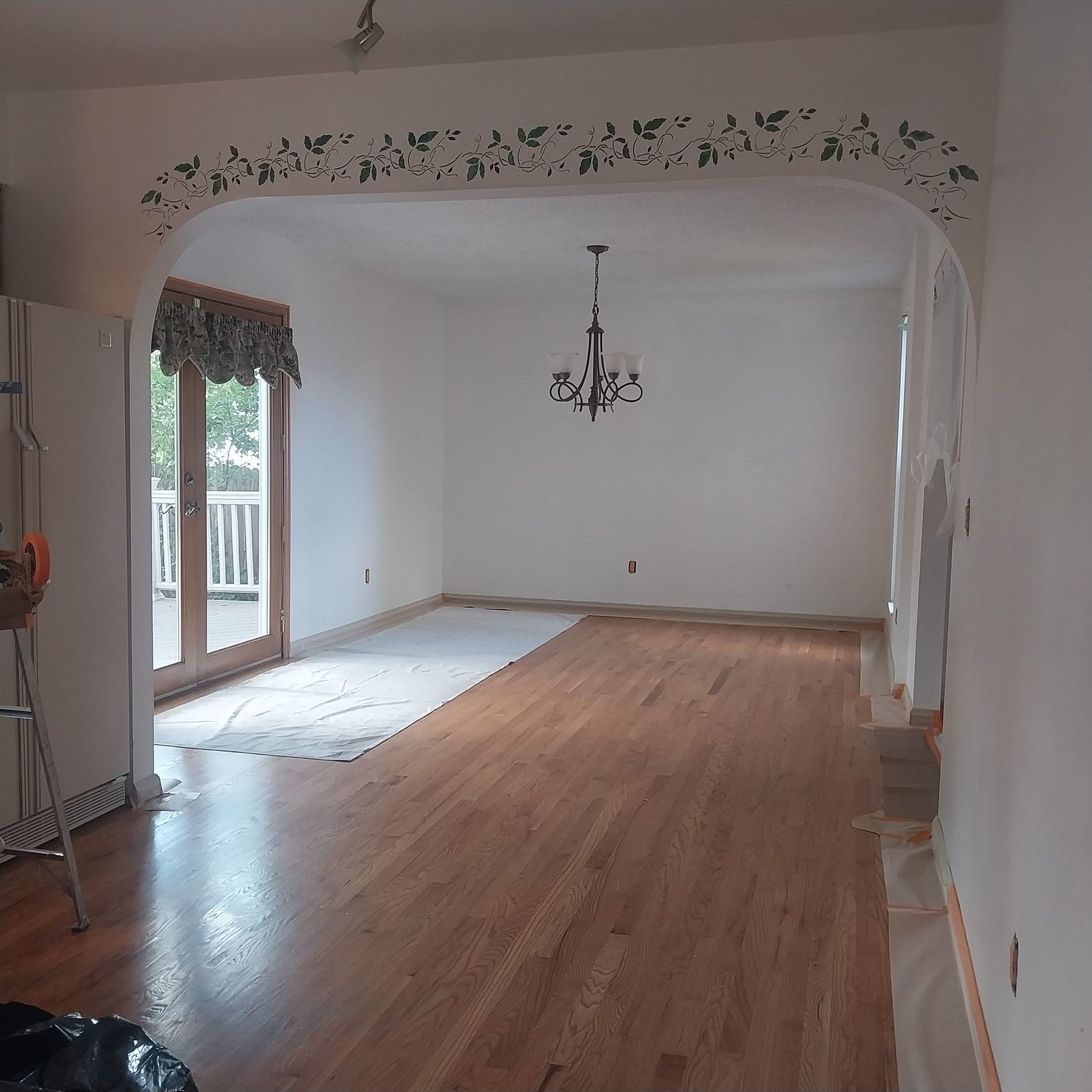 An empty room with hardwood floors and white walls