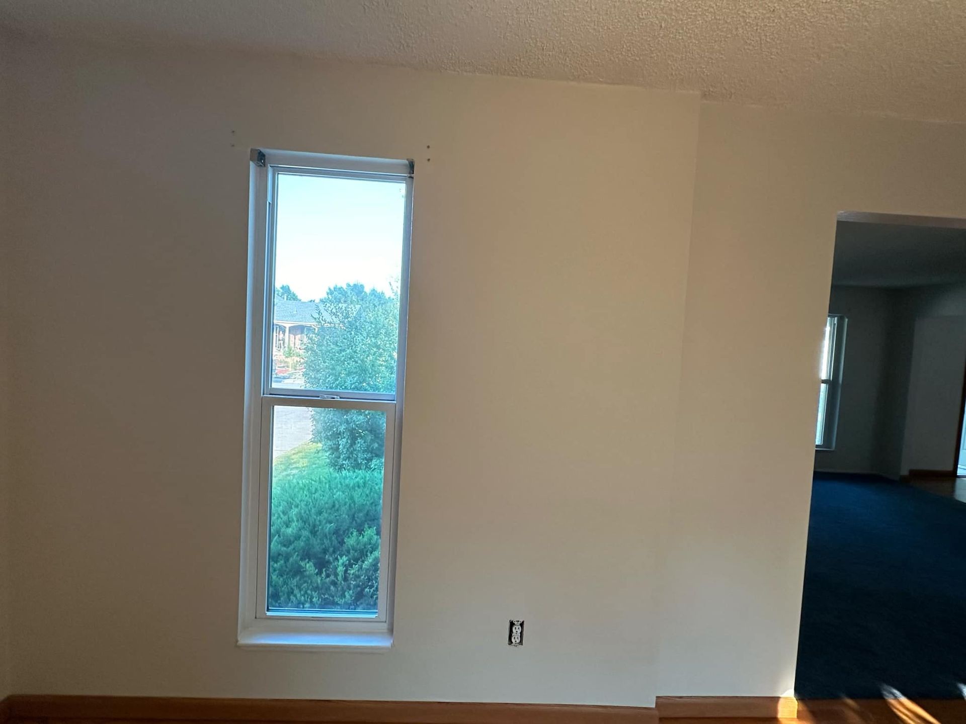 An empty room with a window in the middle of it