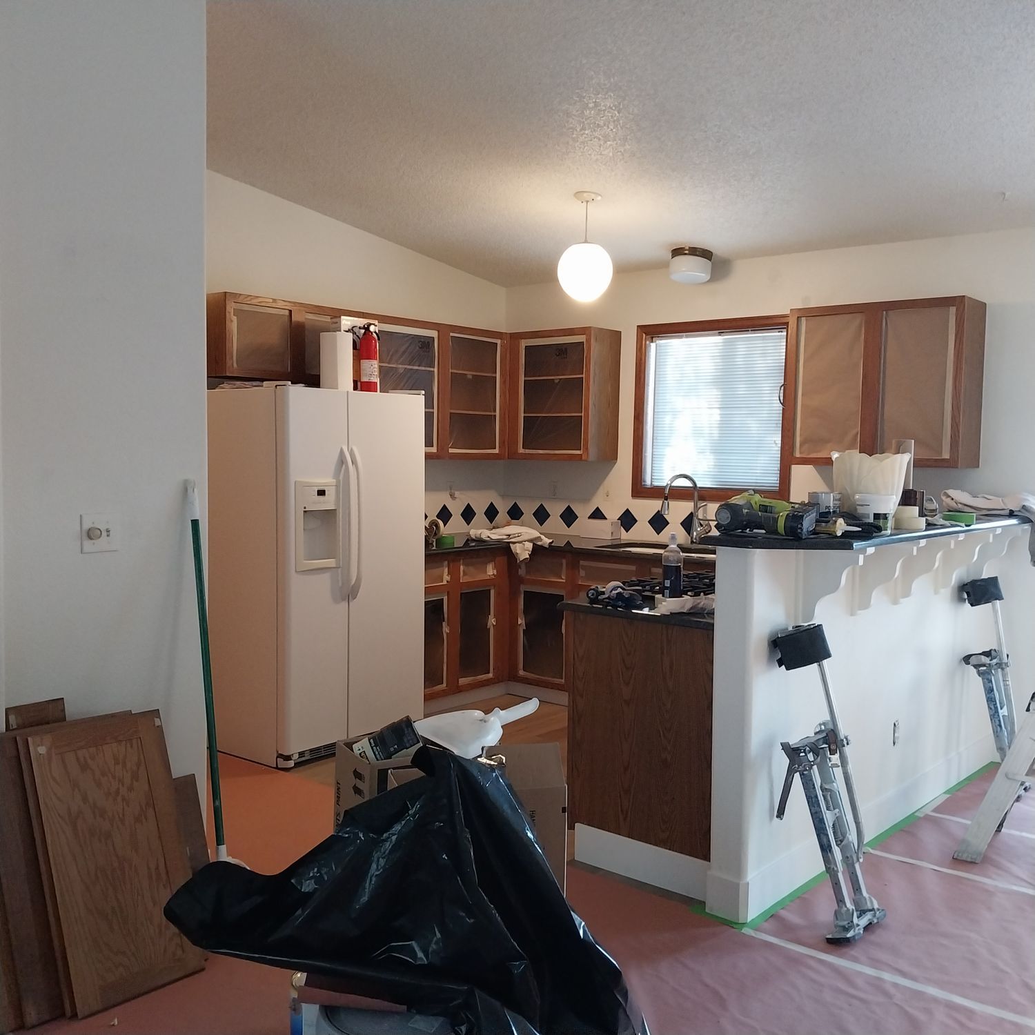 A kitchen with a refrigerator and a fire extinguisher