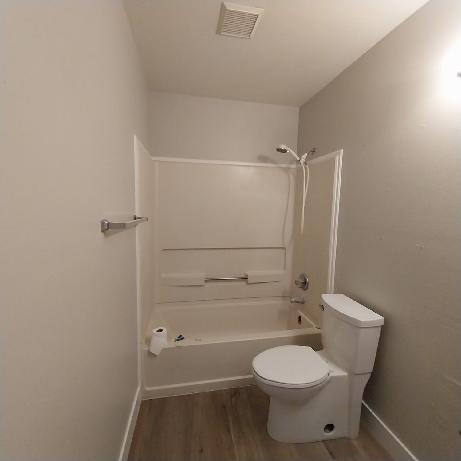 A bathroom with a toilet a bathtub and a shower