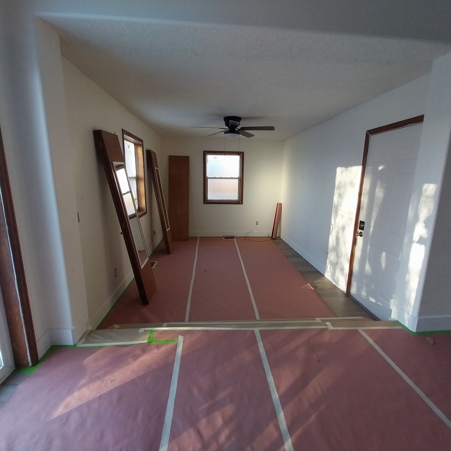 An empty room with a ceiling fan and a window