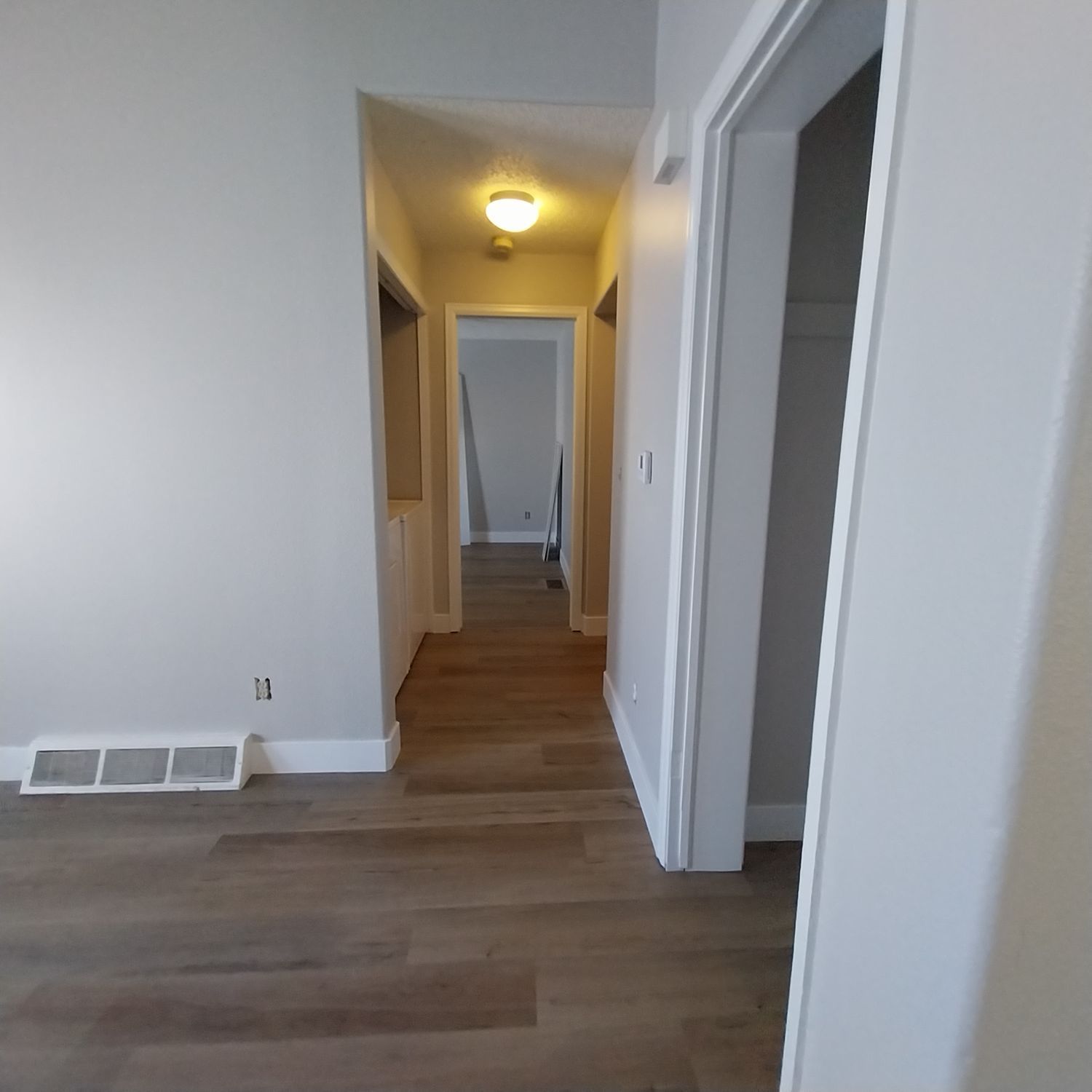 A hallway with hardwood floors and white walls