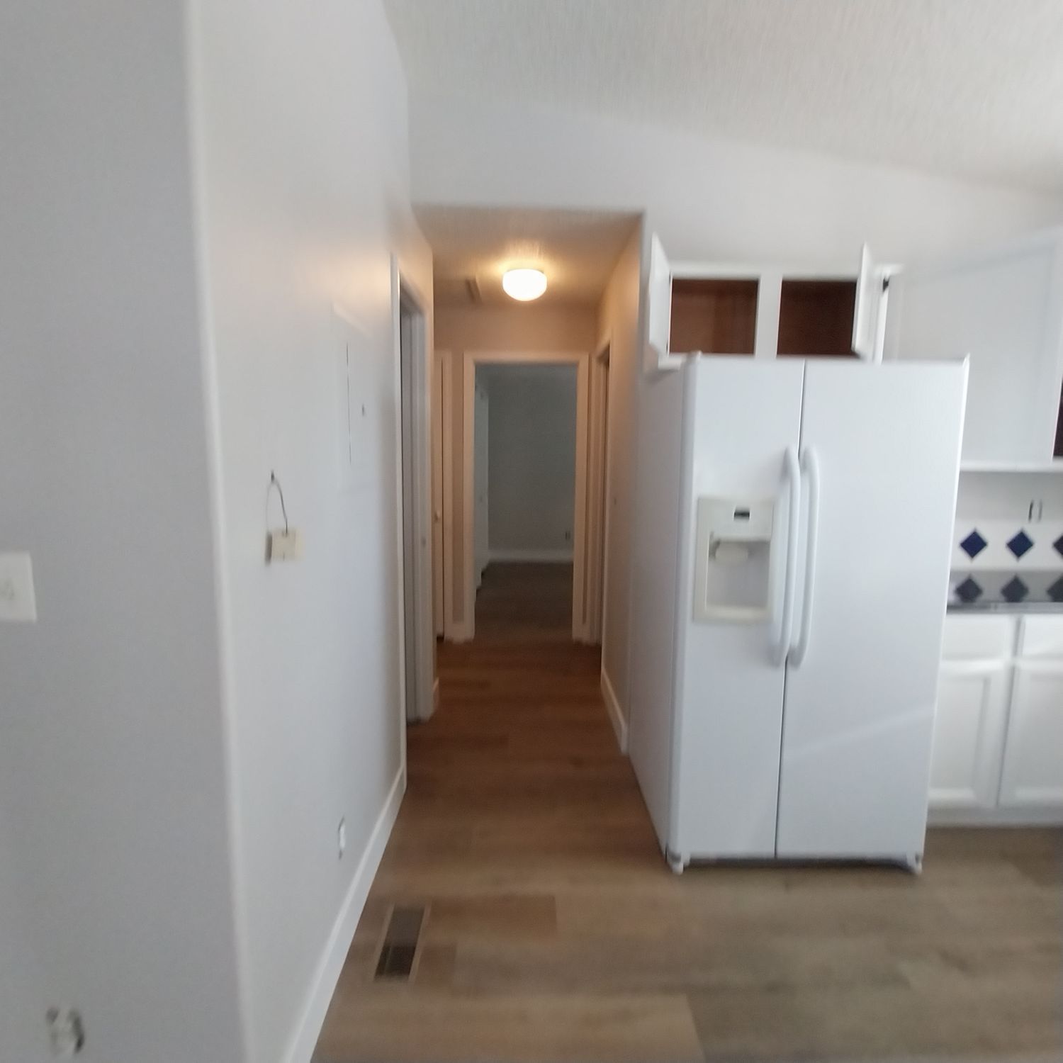 A white refrigerator with a water dispenser in a kitchen