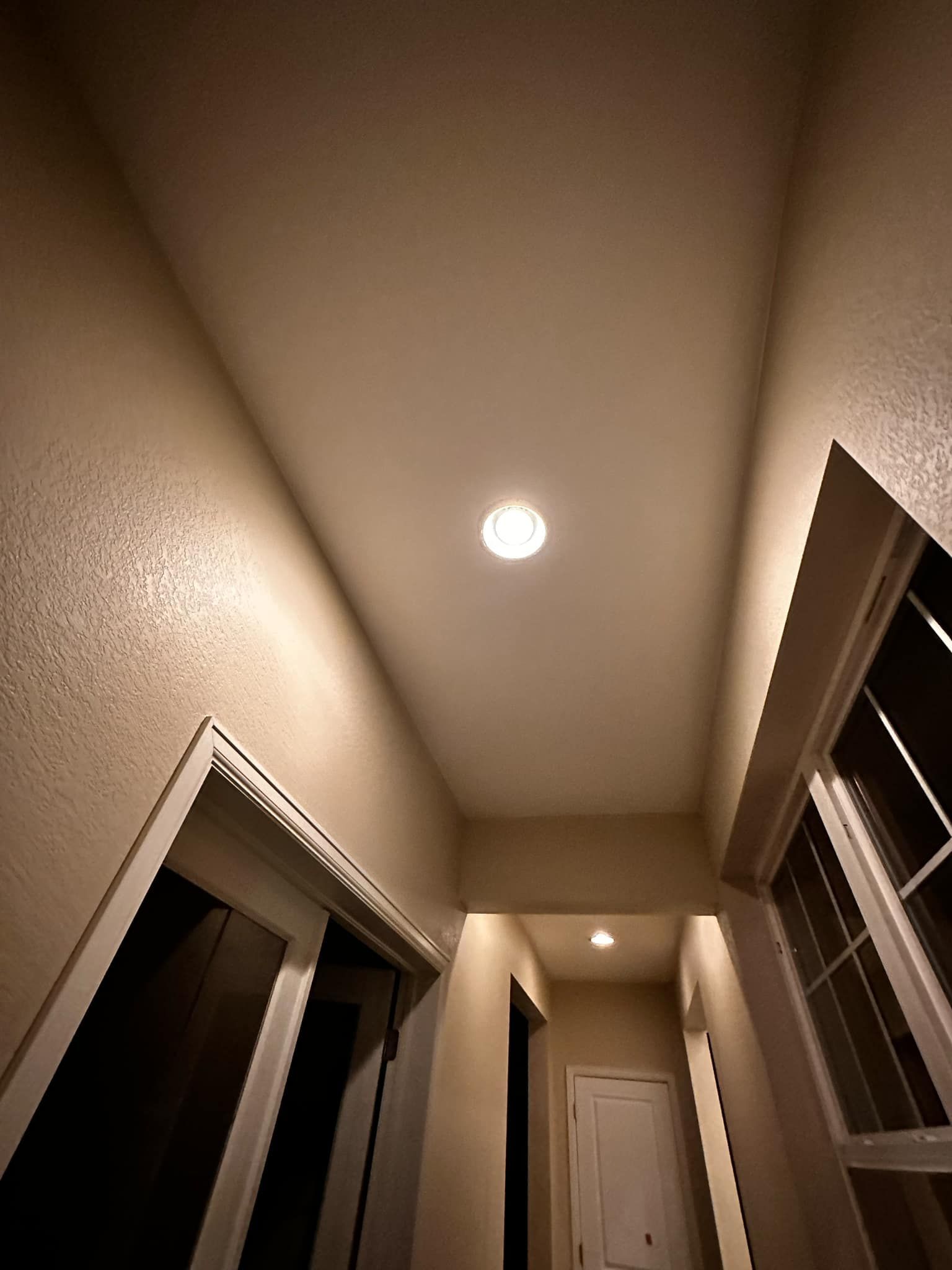 A hallway with a light on the ceiling and a window