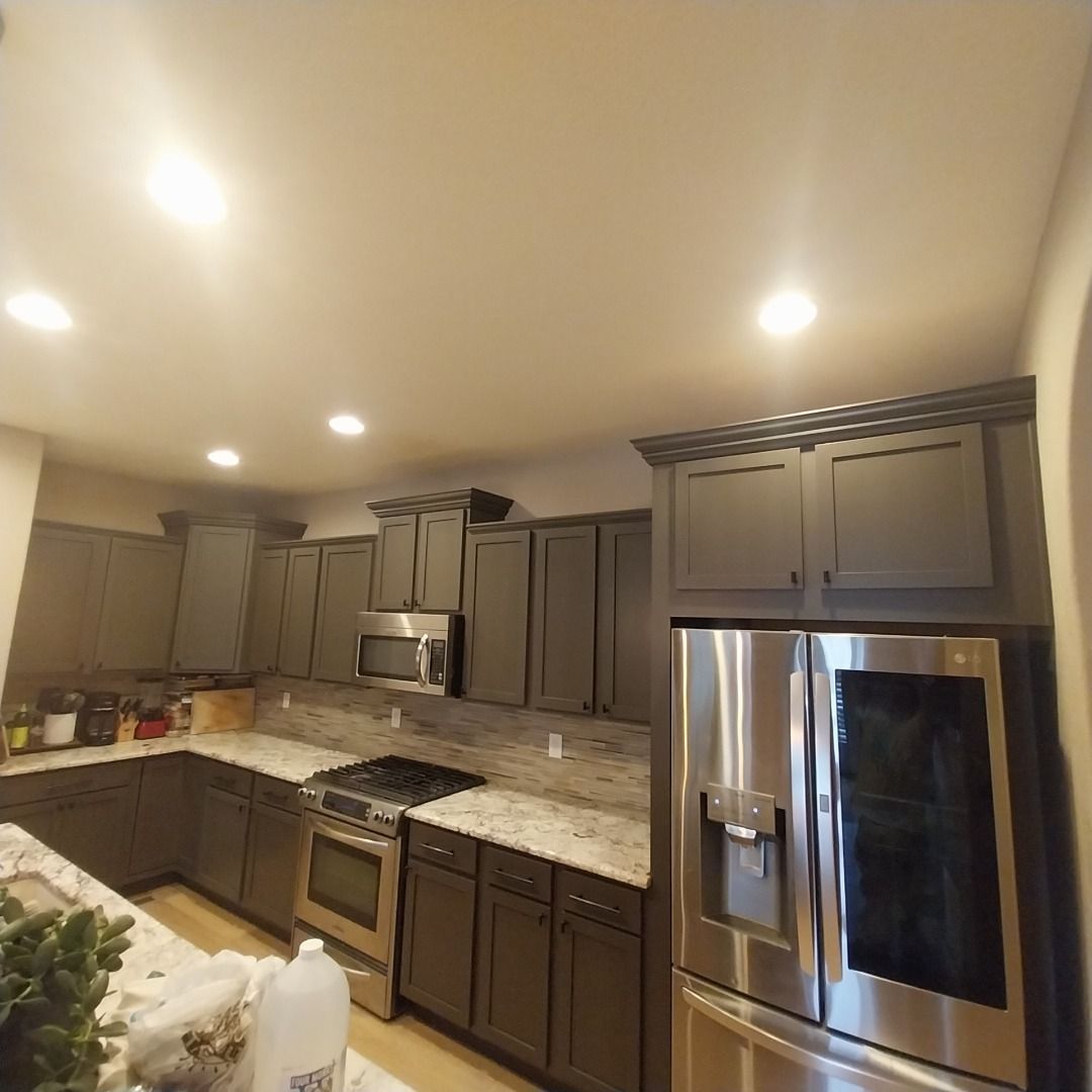 A kitchen with stainless steel appliances and grey cabinets