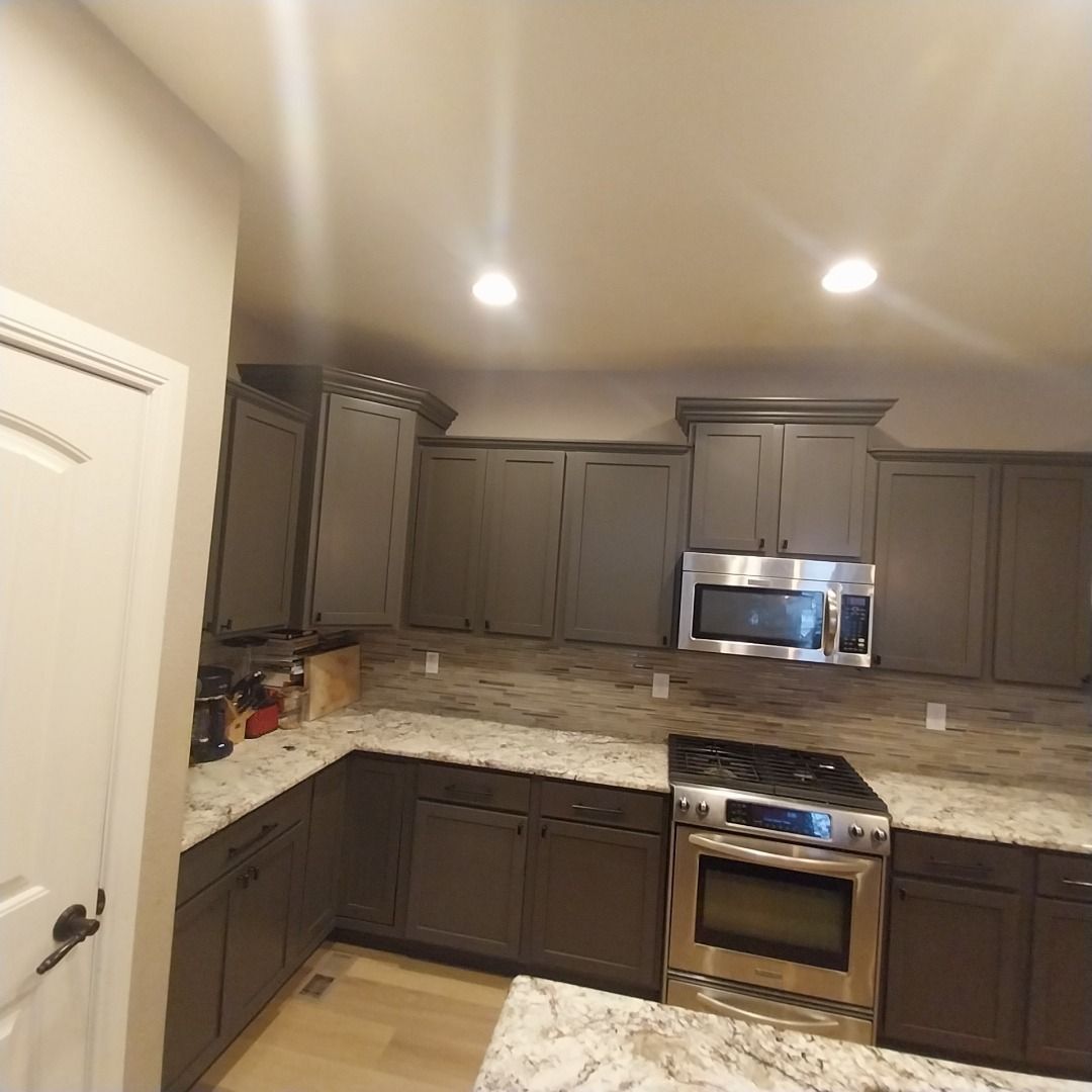 A kitchen with stainless steel appliances and gray cabinets