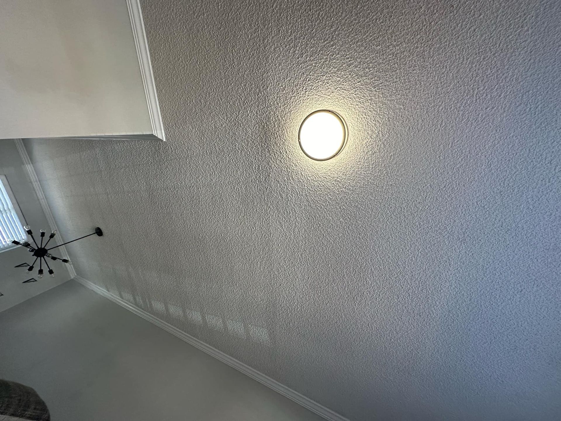 A ceiling with a light on it and a ceiling fan.
