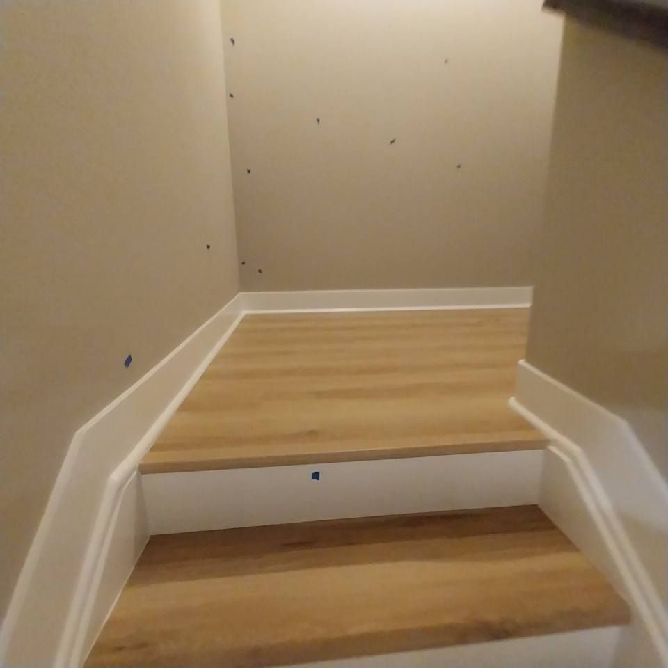 A staircase with wooden steps and white trim in a room.