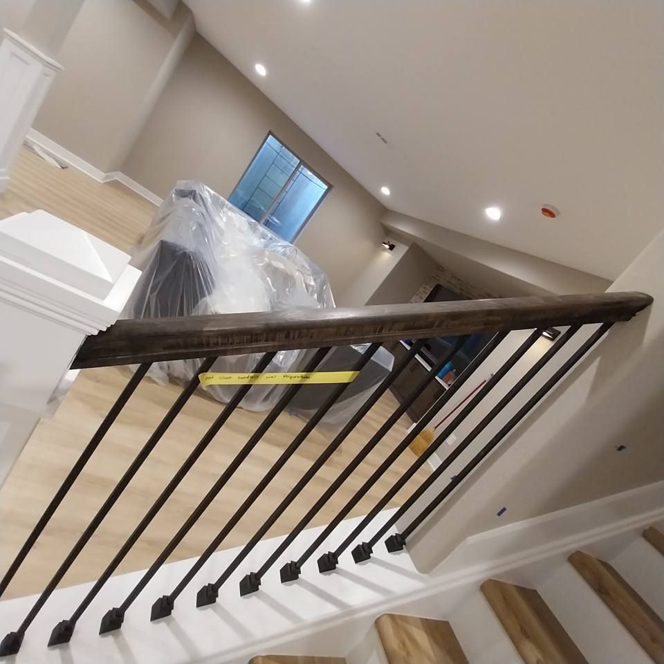 A staircase with a metal railing and a wooden handrail