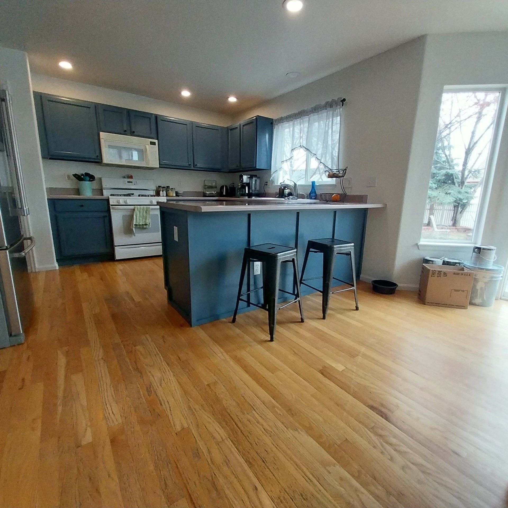 A kitchen with hardwood floors and blue cabinets