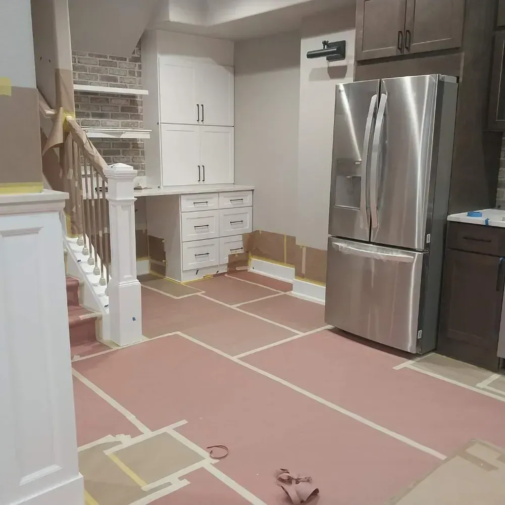 A kitchen with a stainless steel refrigerator and stairs