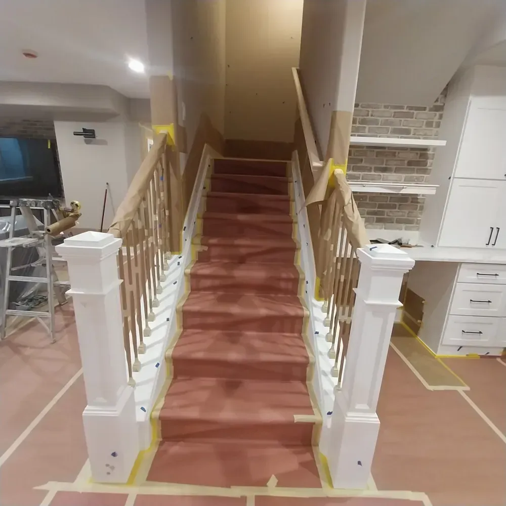 A set of stairs with a white railing and a red carpet