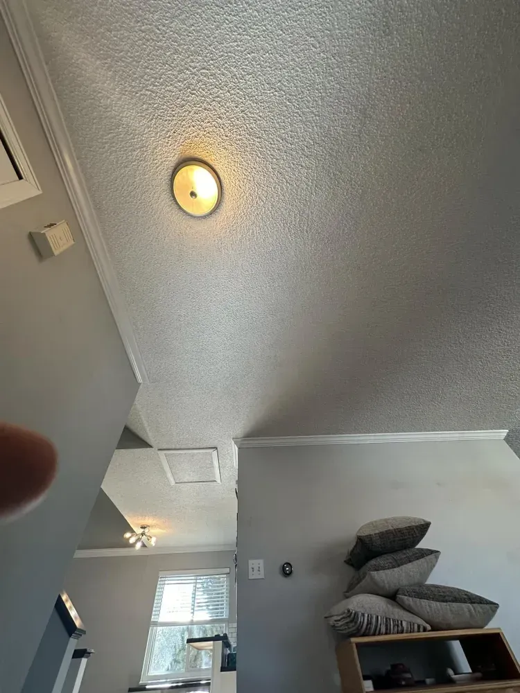 A person is looking up at the ceiling of a living room.