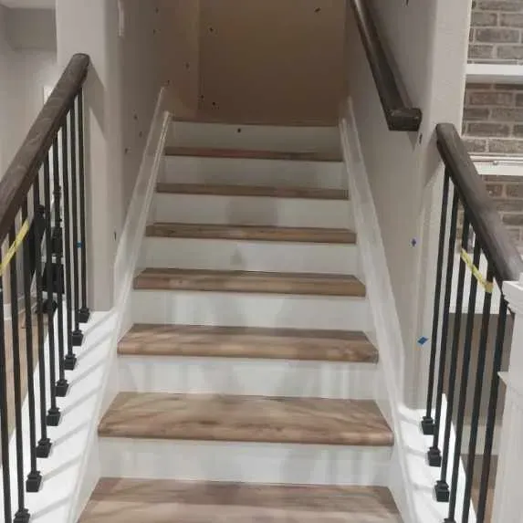 A set of stairs with wooden steps and a metal railing.