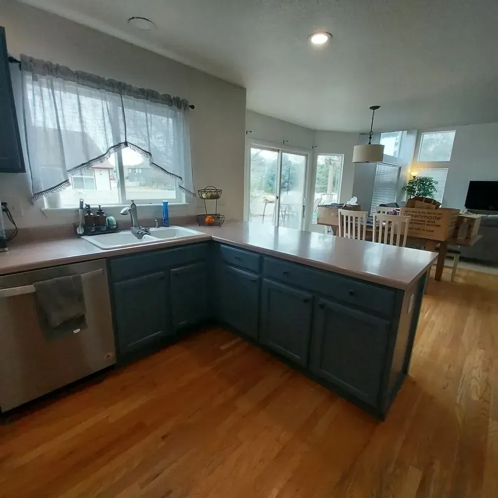 A kitchen with blue cabinets and hardwood floors