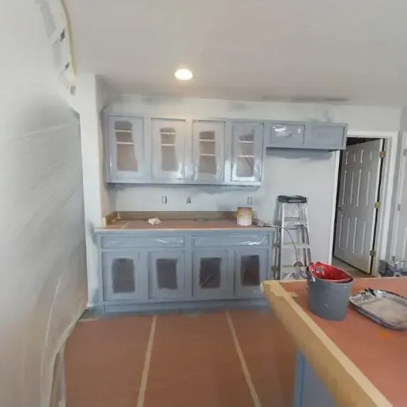 A kitchen with a ladder and a bucket on the counter.