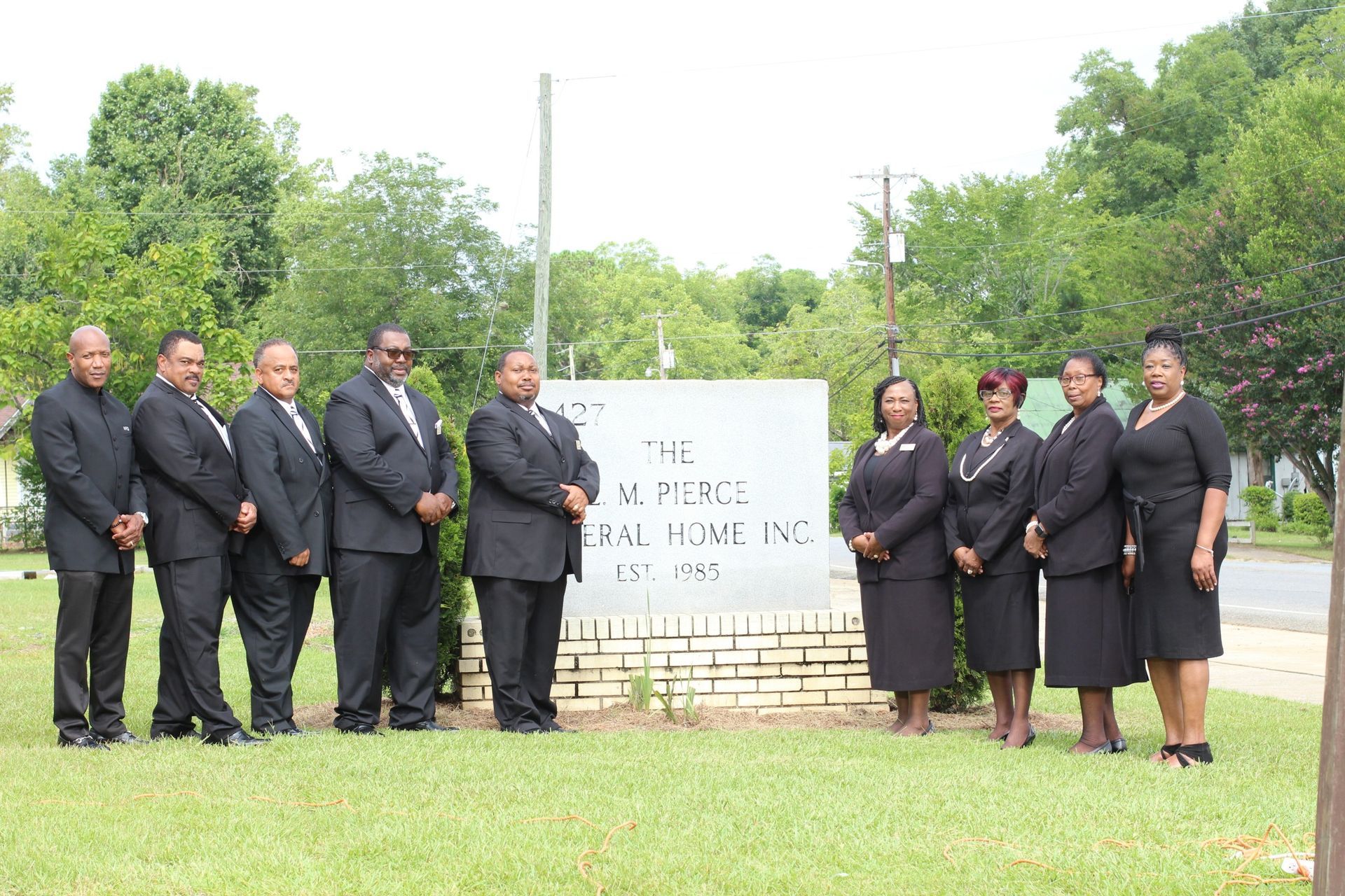 The front door of a house with a porch and plants in front of it.