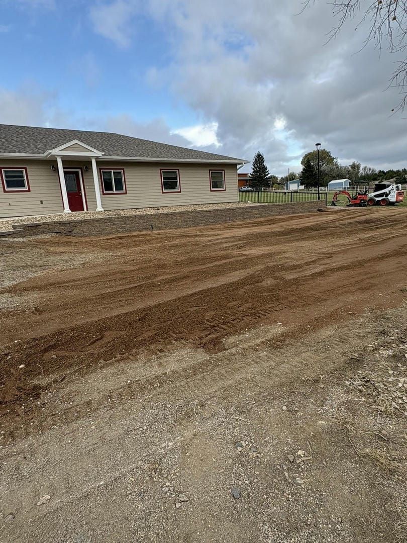 House under construction with dirt lot in front; cloudy sky.