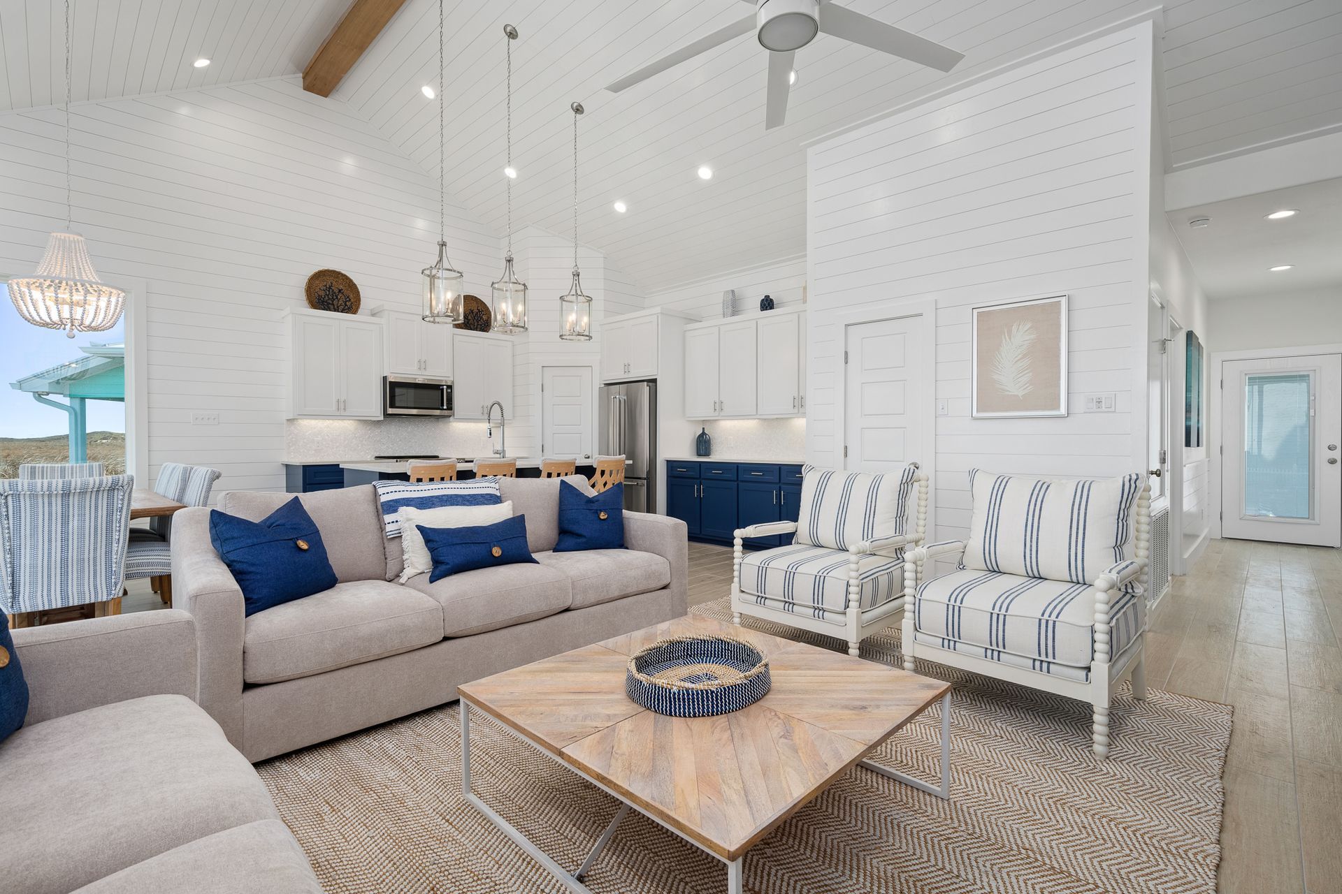 A living room with a couch , chairs , coffee table and ceiling fan.