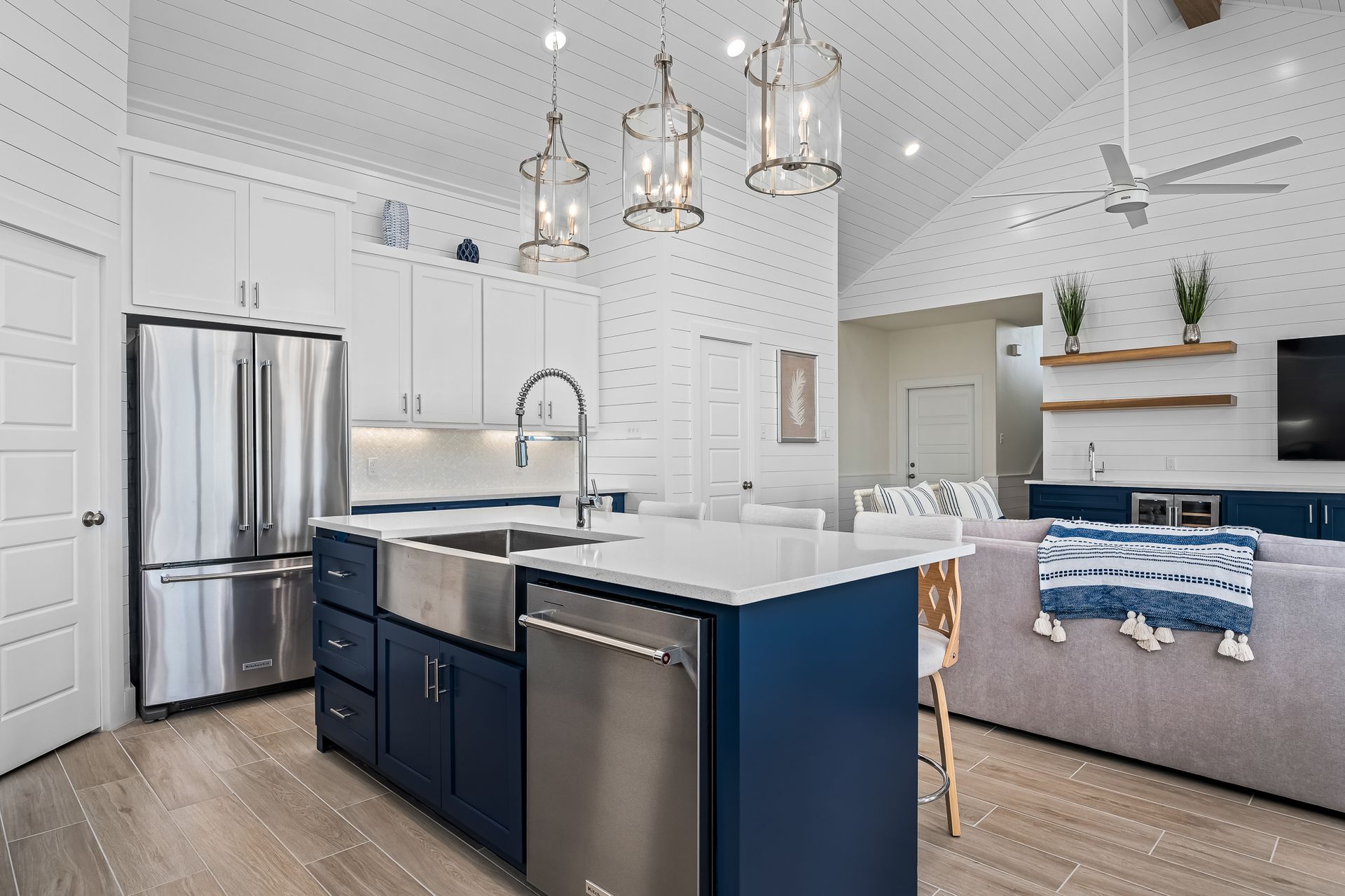 A kitchen with stainless steel appliances and a blue island in the middle.