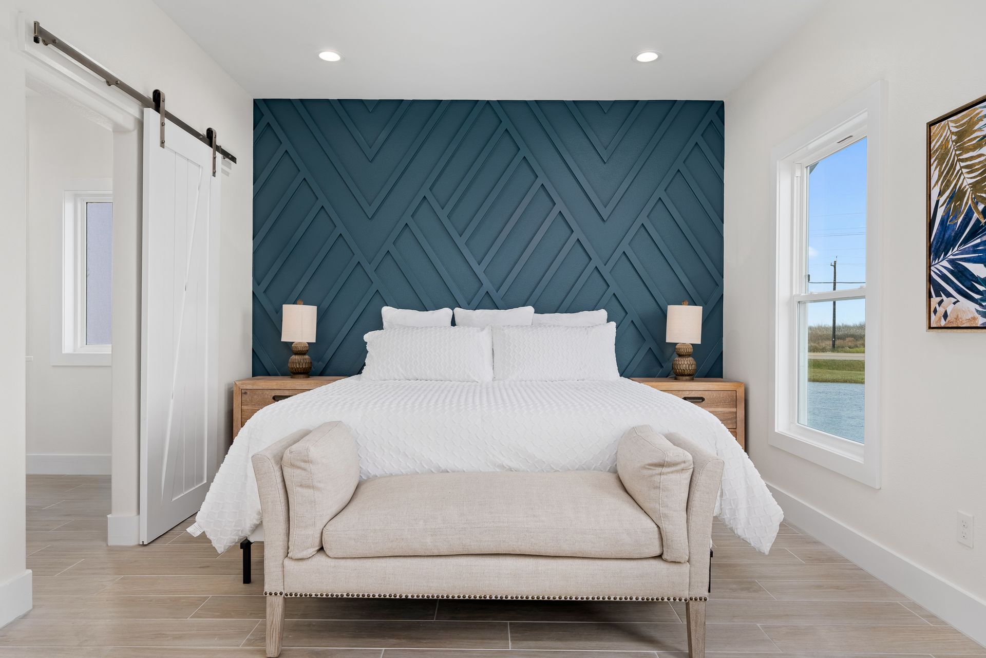 A bedroom with a king size bed and a bench