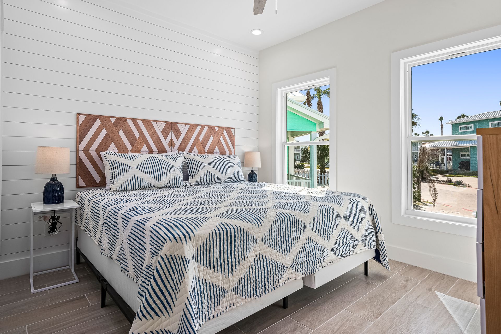 A bedroom with a king size bed and two windows.