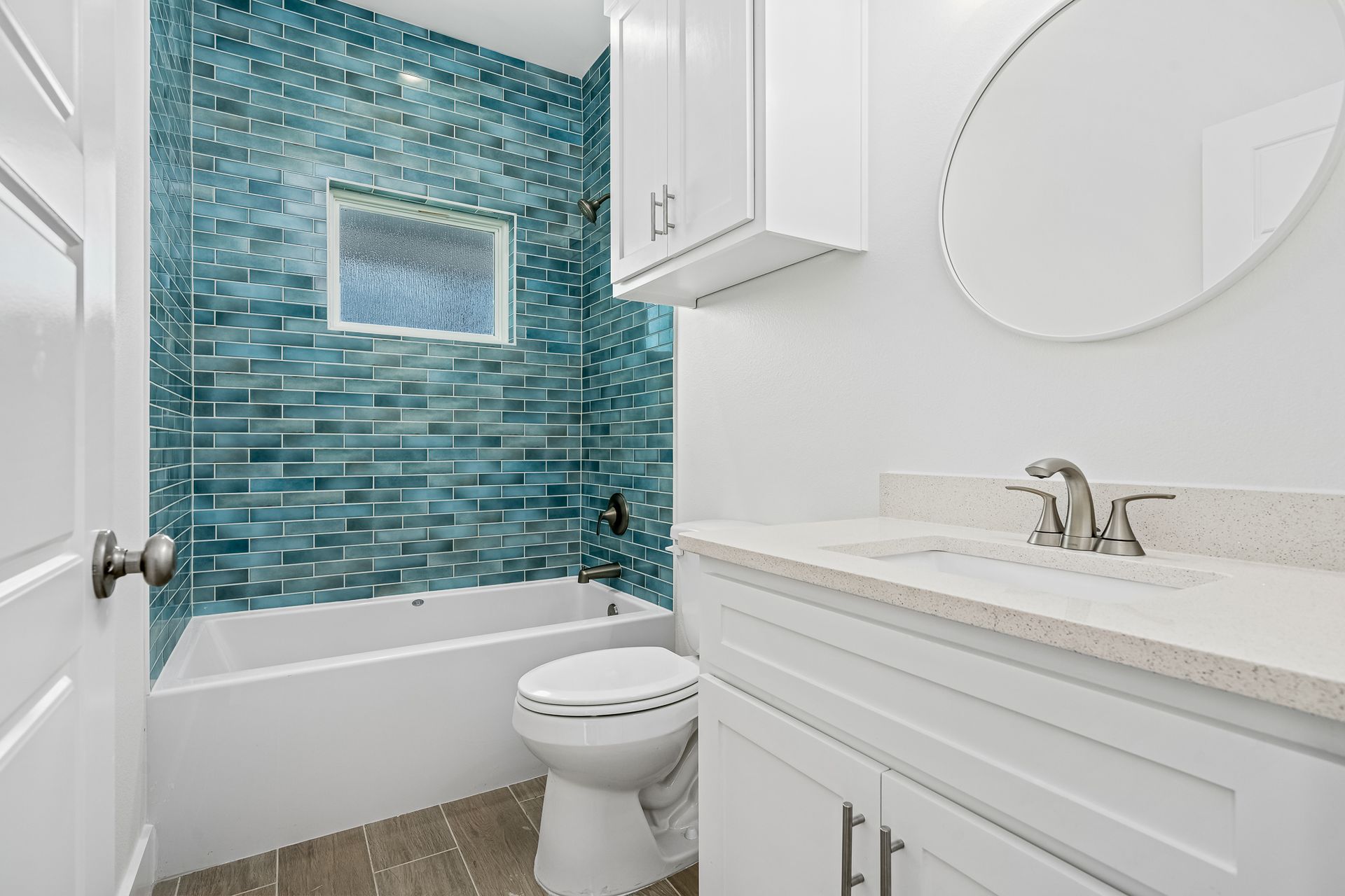 A bathroom with a toilet , sink , bathtub and mirror.