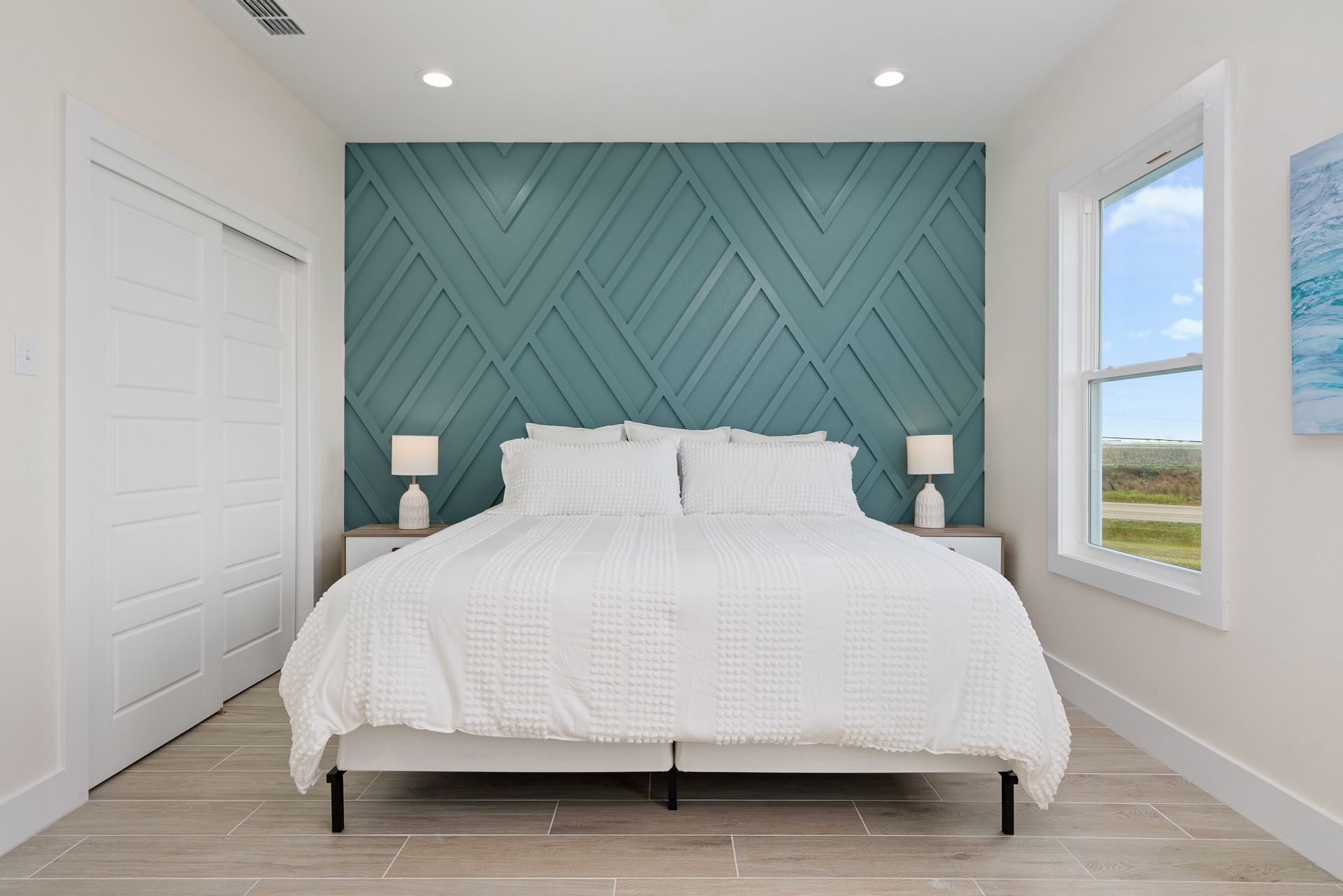 A bedroom with a king size bed and a blue wall.