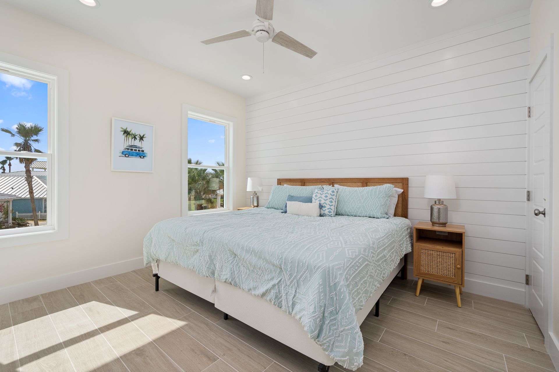 A bedroom with a king size bed and a ceiling fan.