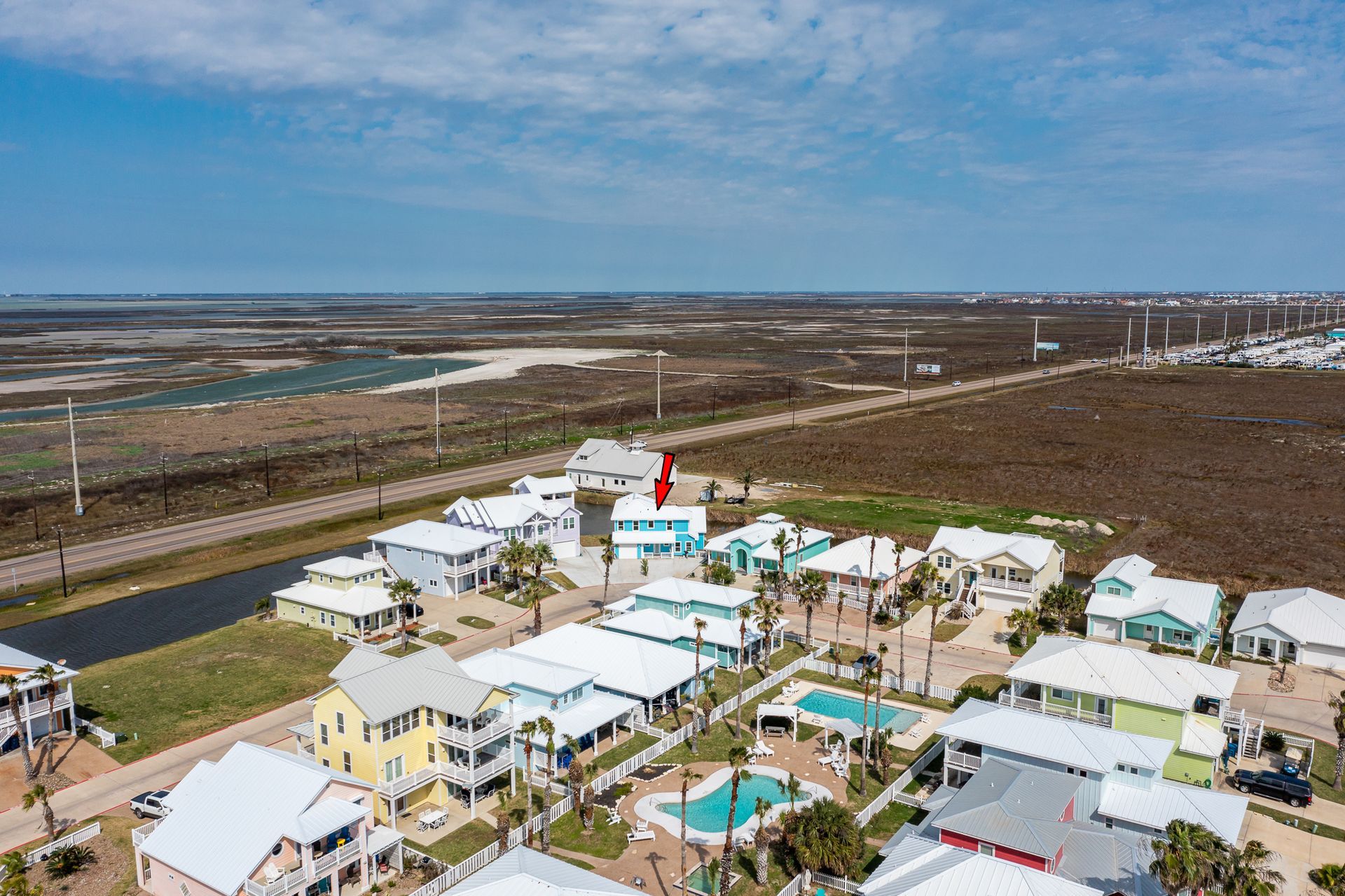 An aerial view of a residential area with lots of houses and a pool.