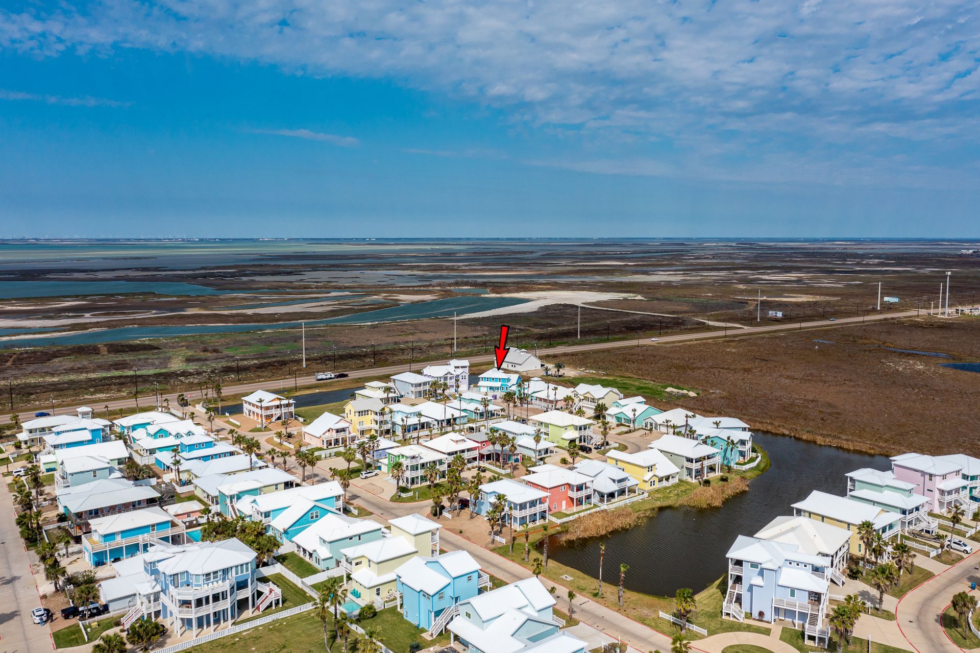 An aerial view of a residential area with lots of houses and a lake in the middle.