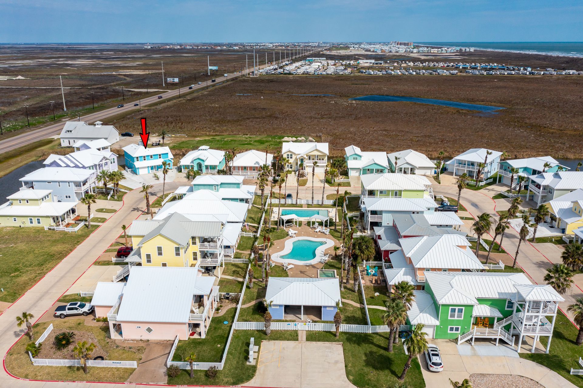 An aerial view of a residential area with houses and a pool