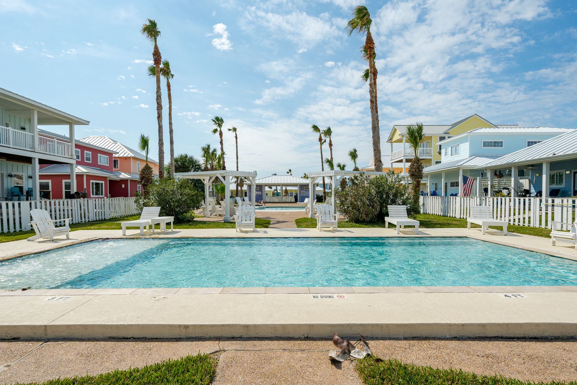 There is a large swimming pool in the middle of a residential area.