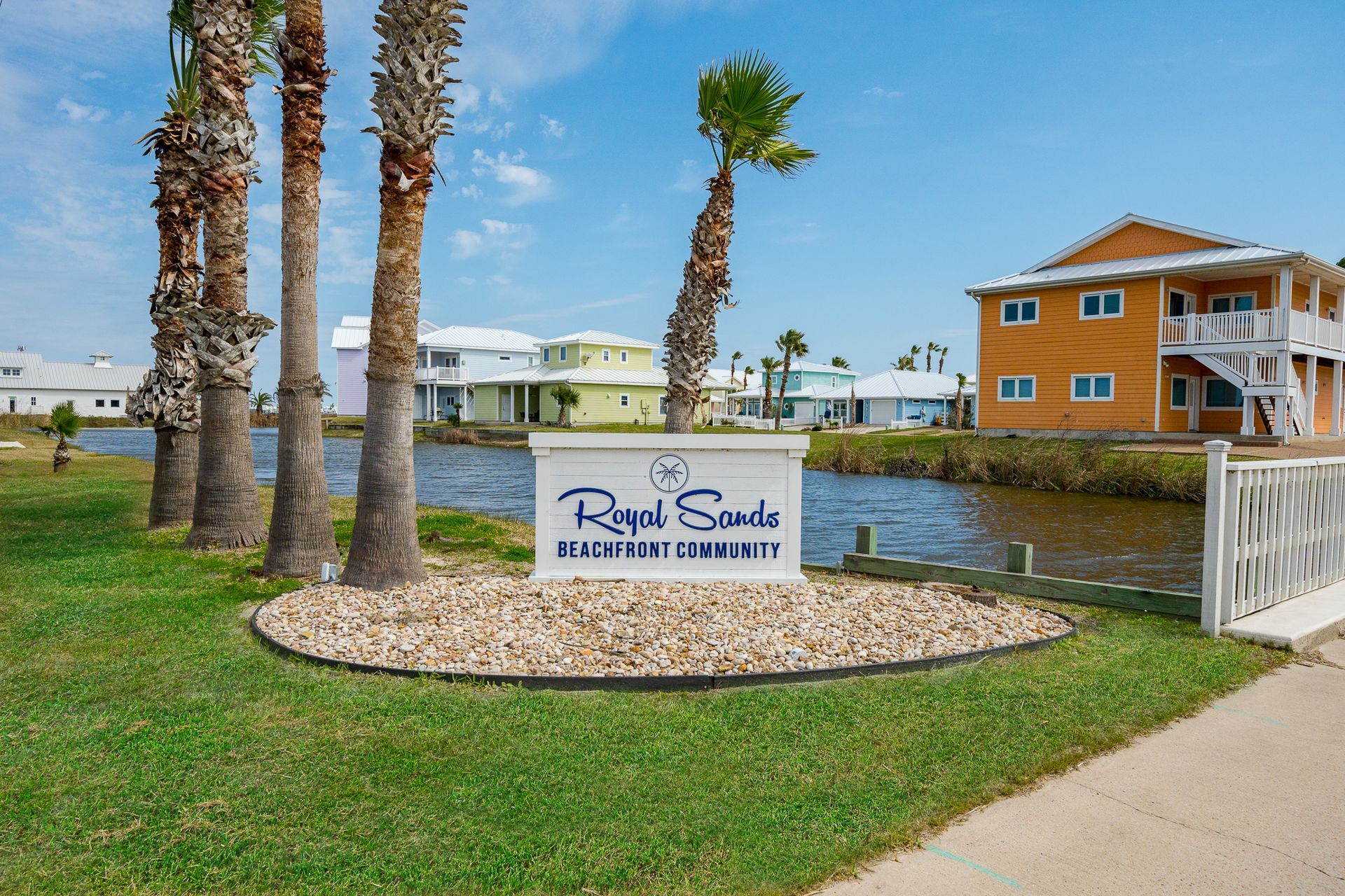 A sign in front of a row of palm trees says royal seas