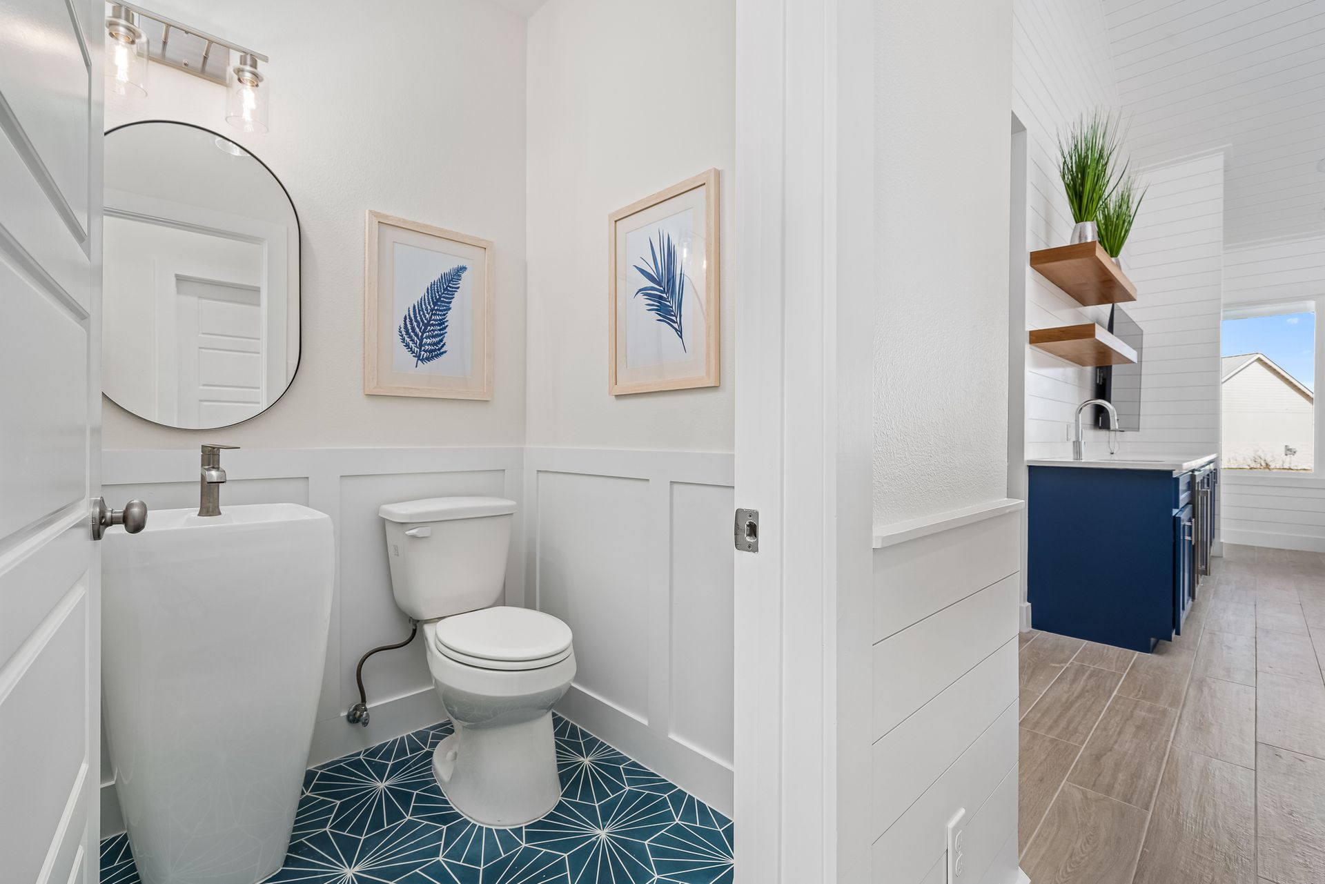 A bathroom with a toilet , sink and mirror.