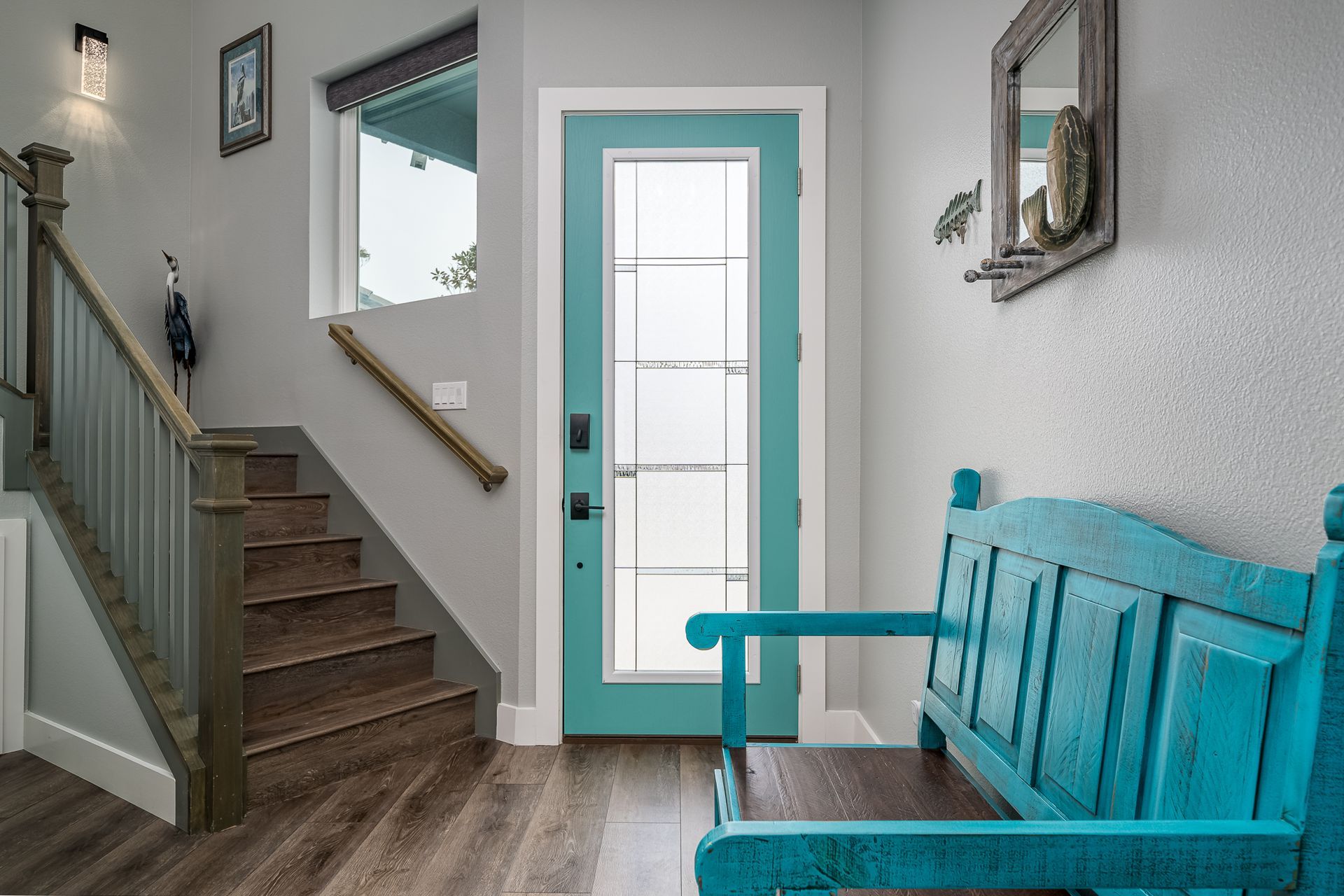 There is a blue bench in the hallway next to the stairs.