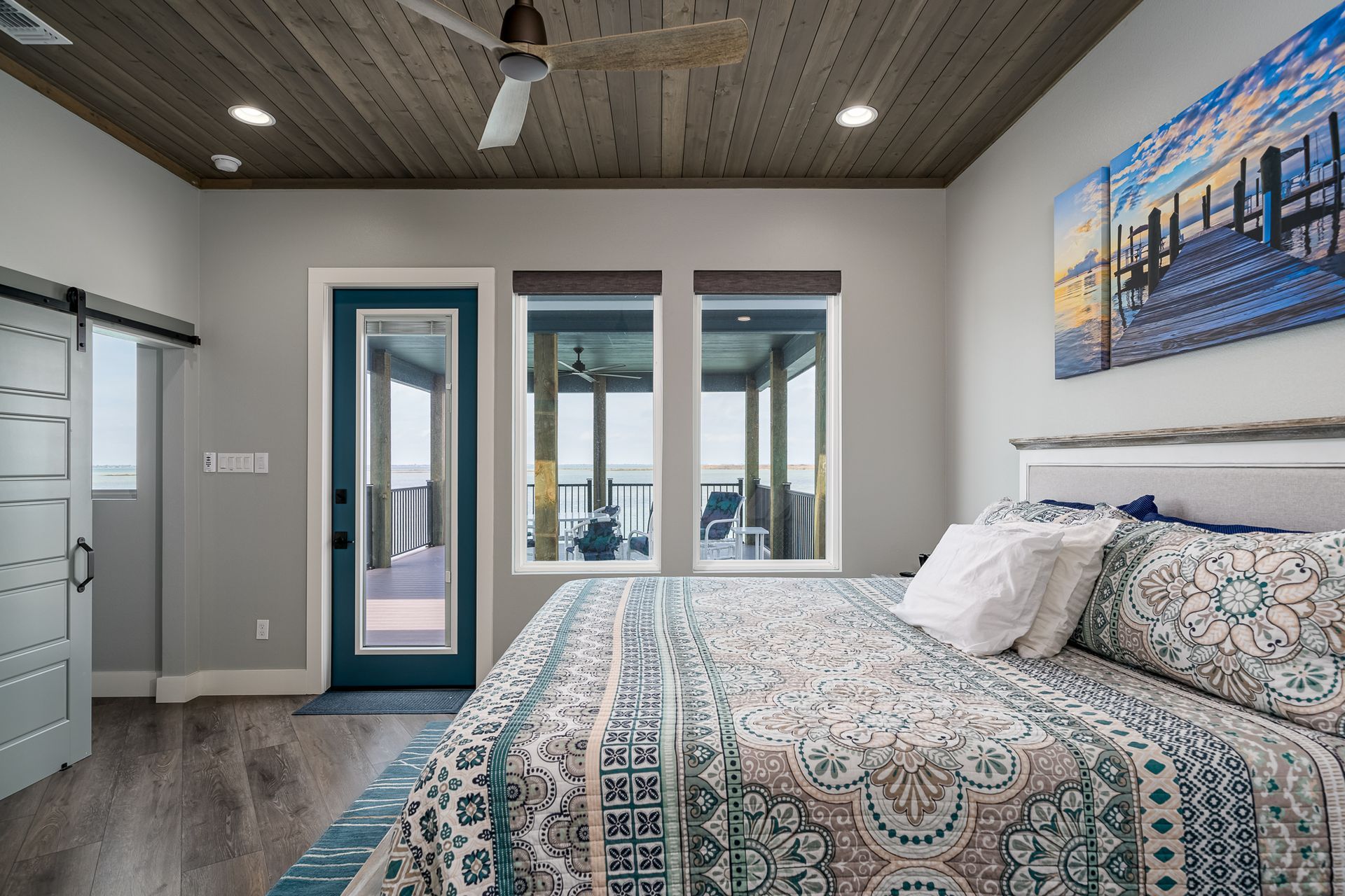 A bedroom with a king size bed and a ceiling fan.