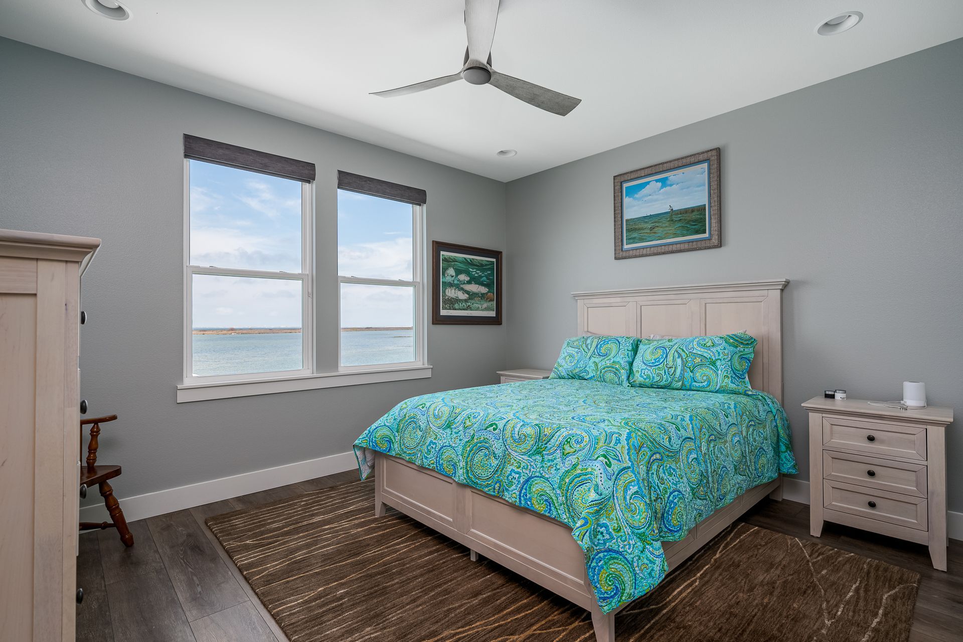 A bedroom with a king size bed and a ceiling fan.