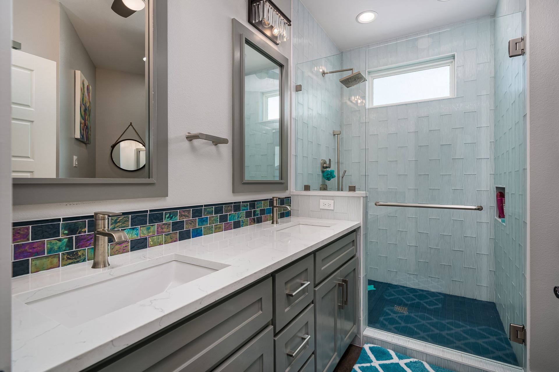 A bathroom with two sinks and a walk in shower.