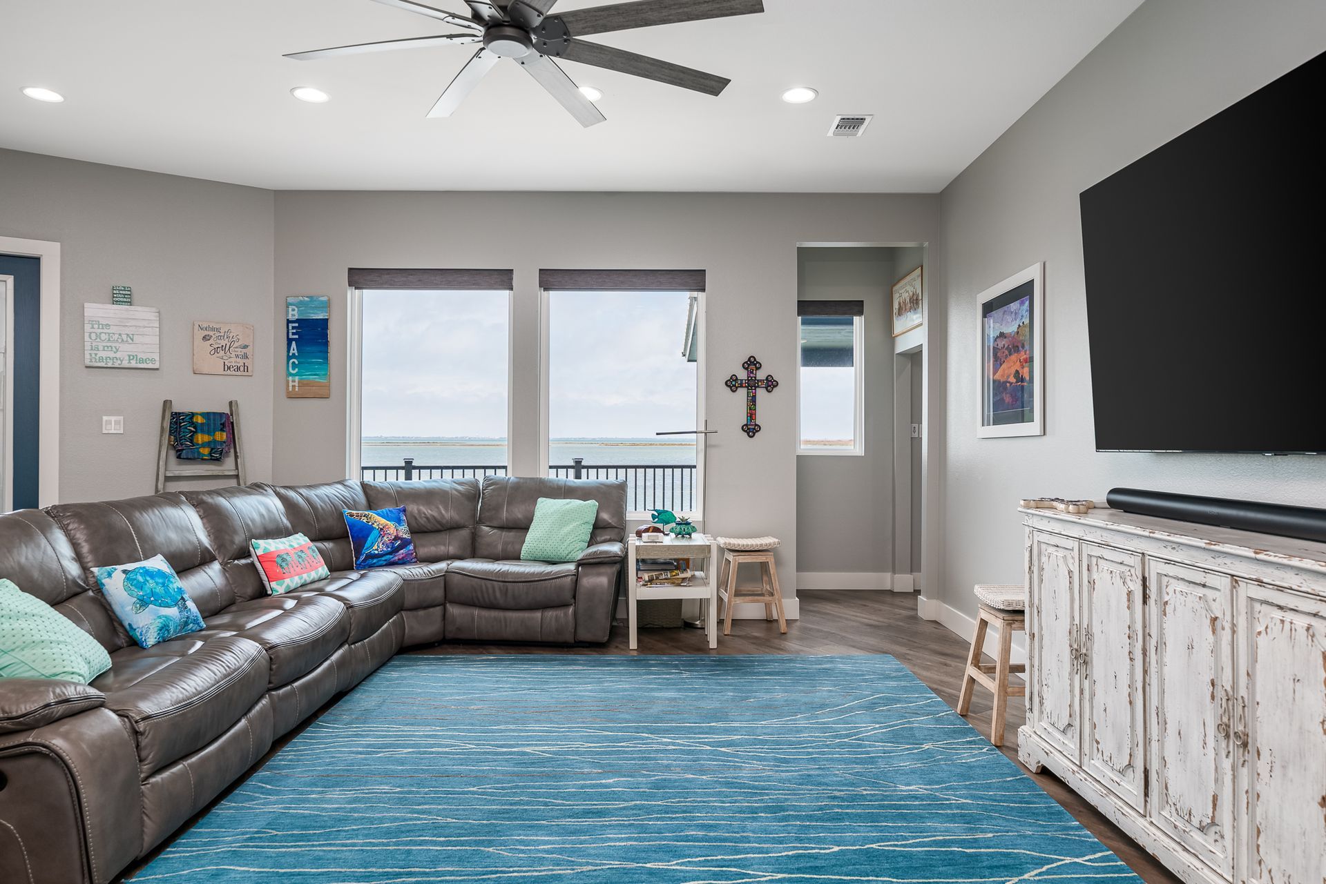 A living room with a large sectional couch and a flat screen tv.