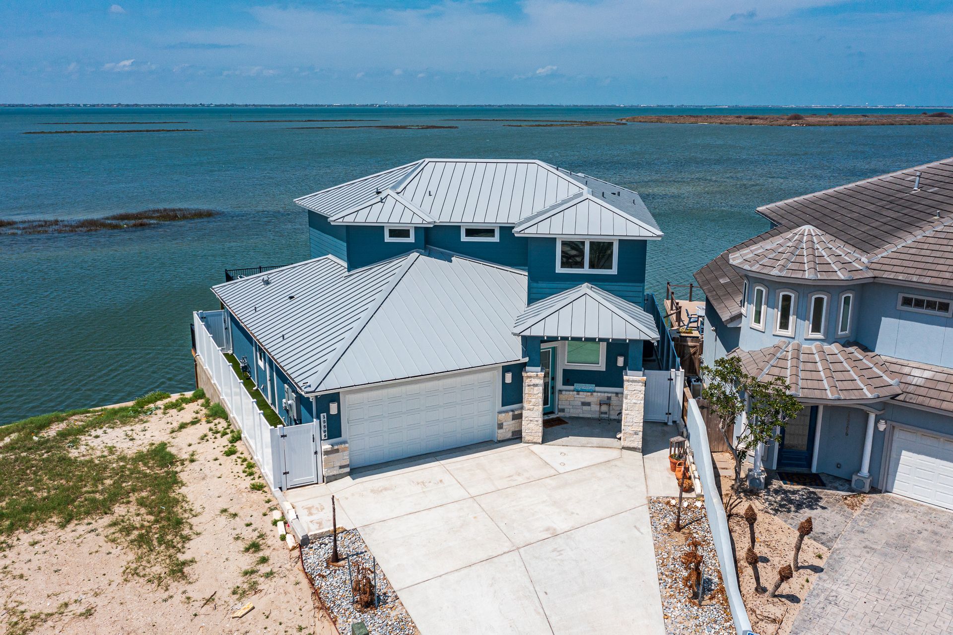 An aerial view of a house next to a body of water
